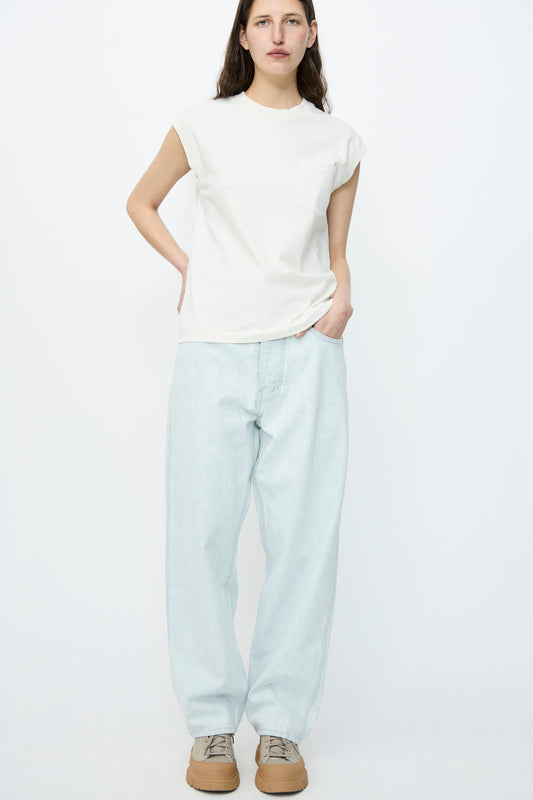 A person in a white t-shirt and Jesse Kamm's Japanese Denim California Wide in Pale Blue stands against a plain white backdrop, completing their look with tan shoes.