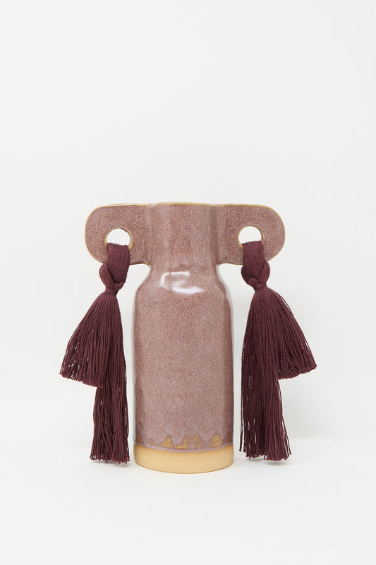 Vase #606 in Burgundy by Karen Tinney is a petite, handmade stoneware vase with a matte mauve finish, wide horizontal handles, and two dark burgundy tassels on each side.