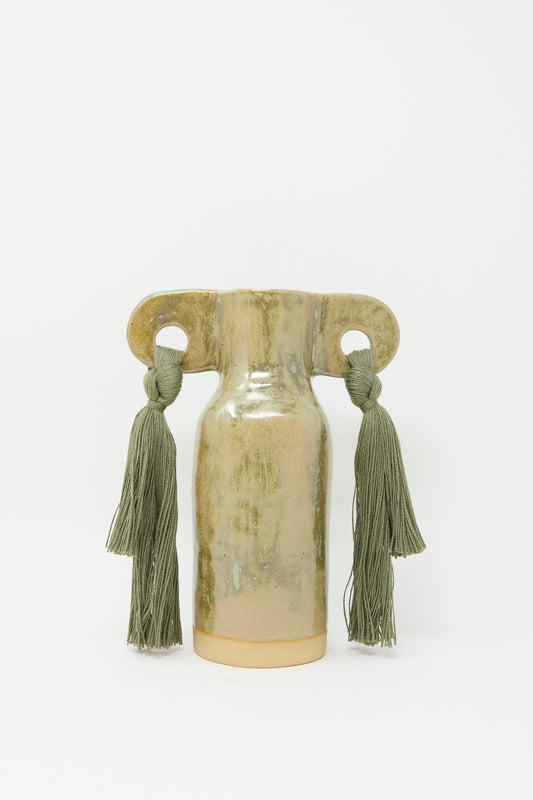Karen Tinney’s Vase #606 in Olive is a handmade stoneware petite vase featuring two large handles with green tassels and a soft olive glaze, set against a plain white background.