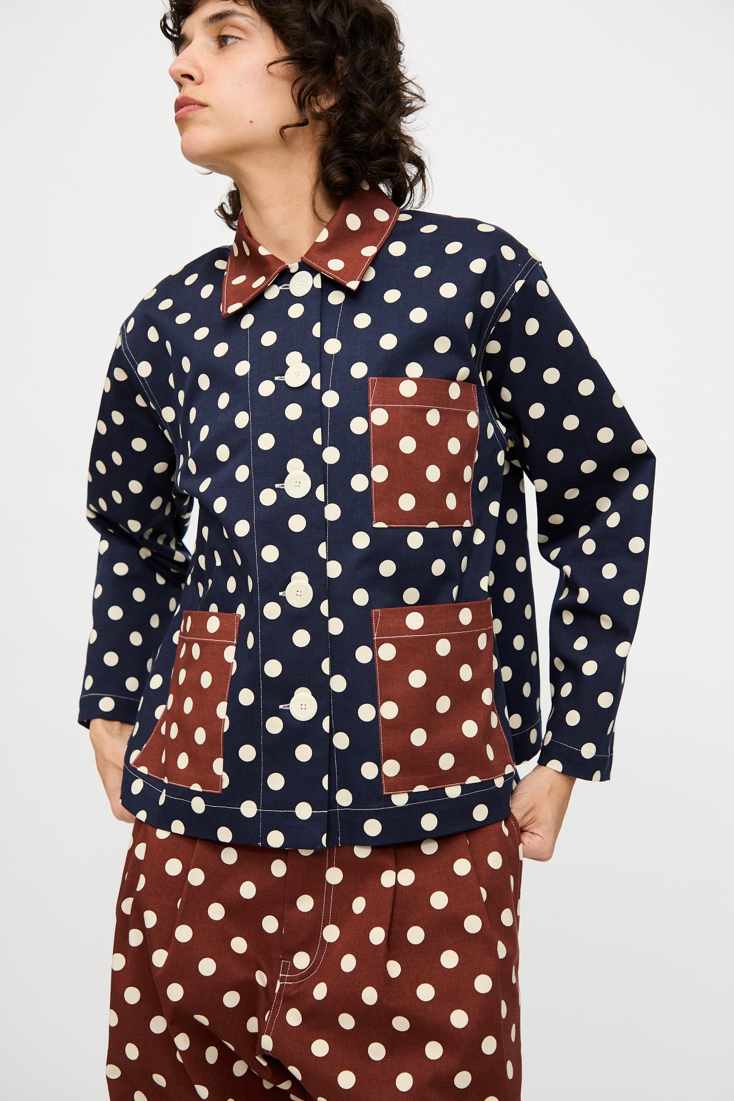 A person wears the KasMaria Cotton Twill Shirt Jacket in Polka Dot with patch pockets, paired with matching polka dot pants, against a plain light background.