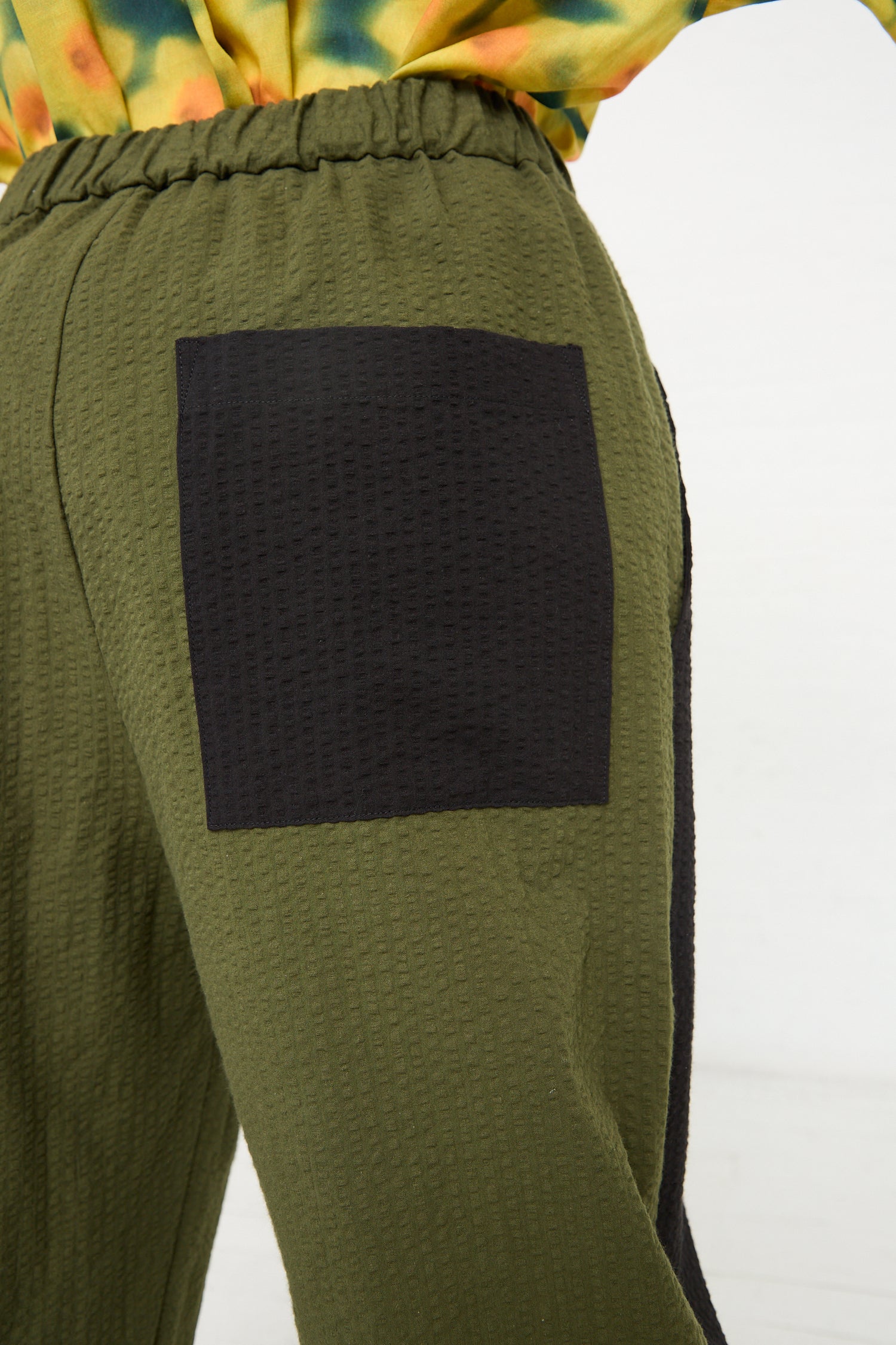 Close-up of KasMaria Cotton Seersucker Work Pant in Combo Color with a dark patch on the pocket area.