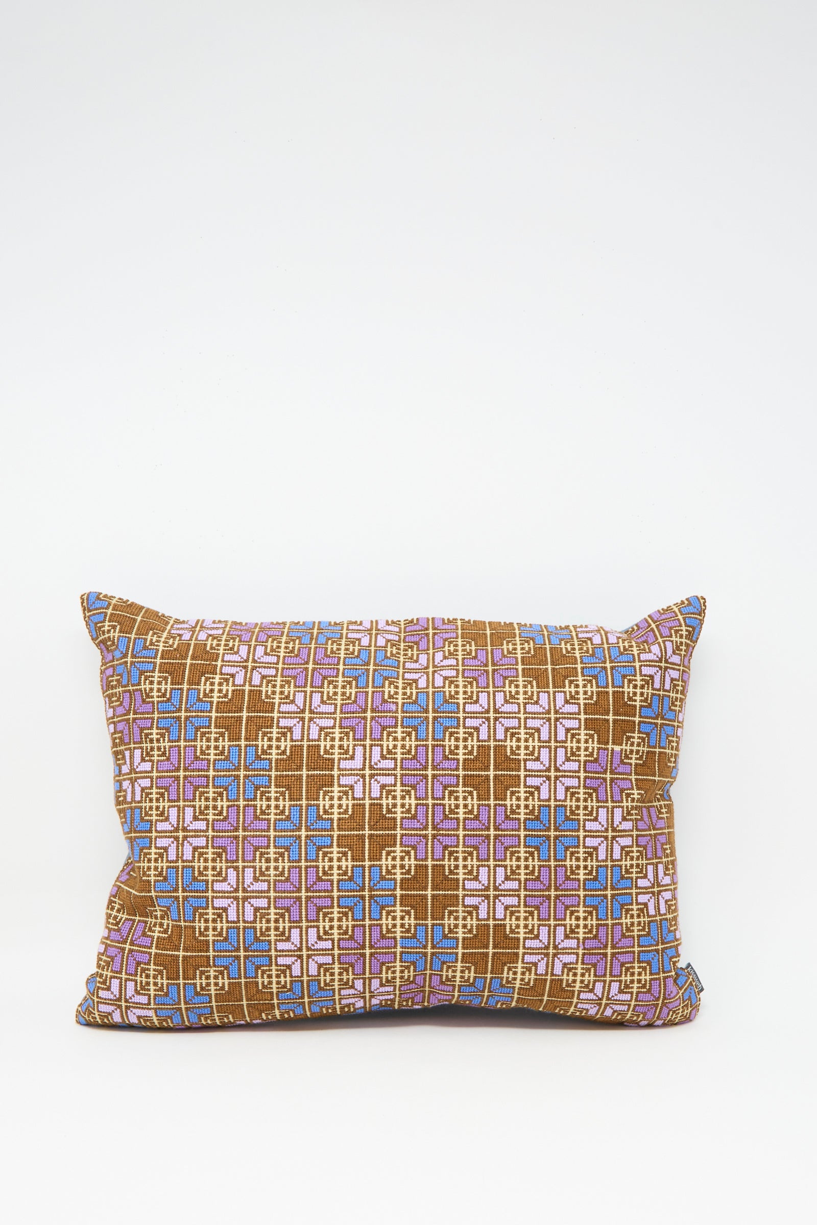 The Kissweh Rana Hand Embroidered Pillow in Lilac and Cognac features a geometric design on white Belgian linen and includes a plush down feather insert for comfort.