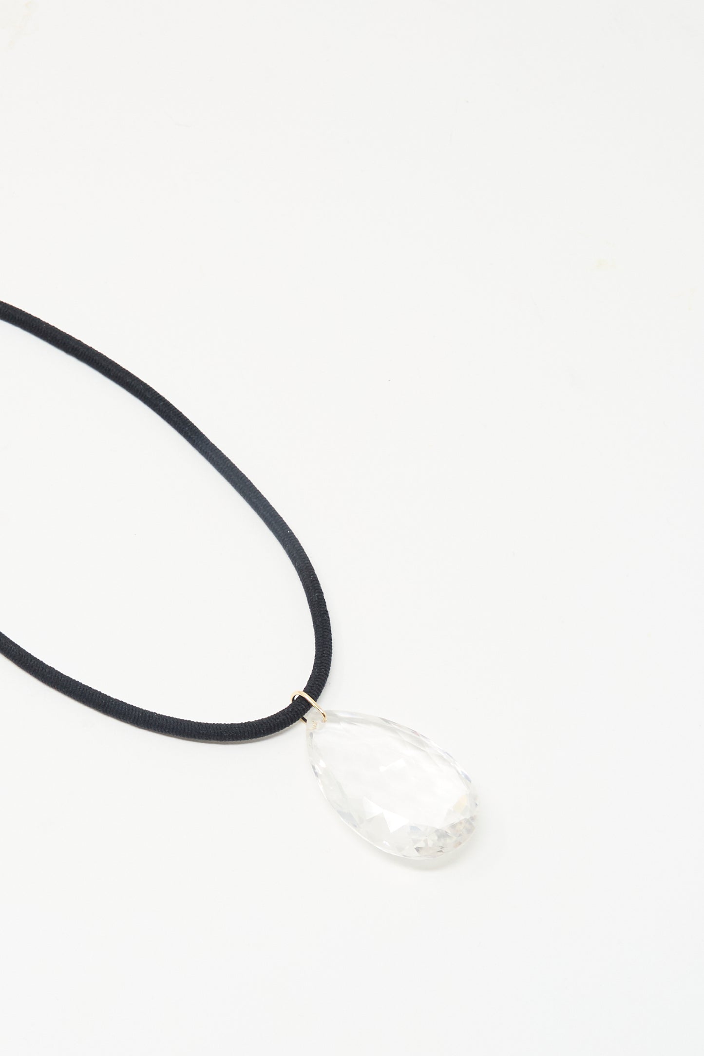 Laoli’s “The Grande Drop in Black Cord and Quartz” features a handmade black cord necklace with a 150-carat clear faceted quartz teardrop pendant, crafted in Paris and shown on a white background.