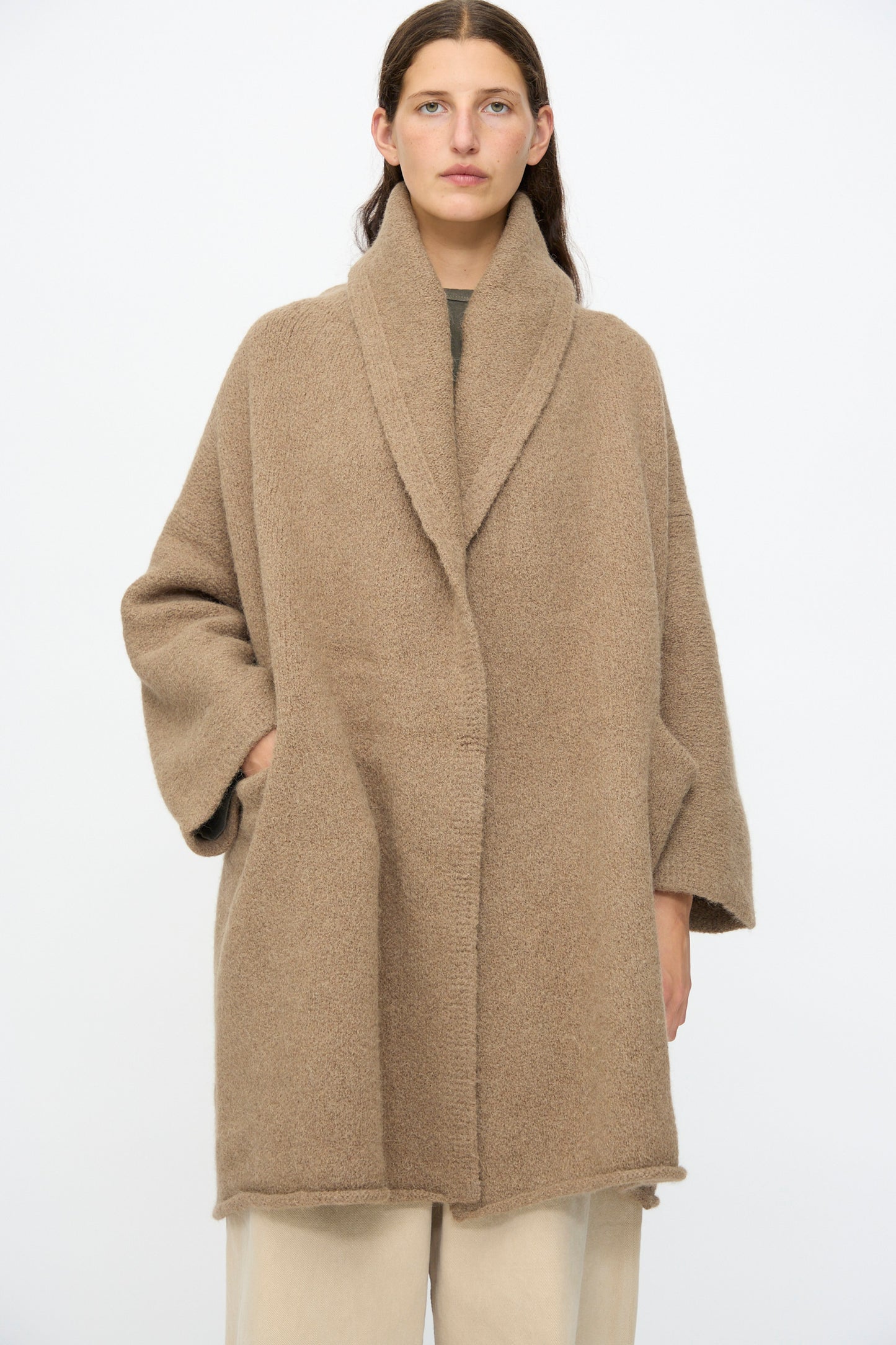 Model wearing the Lauren Manoogian Capote Coat in Tobacco—an oversized alpaca wool design with wide sleeves and a shawl collar—standing against a plain white background.