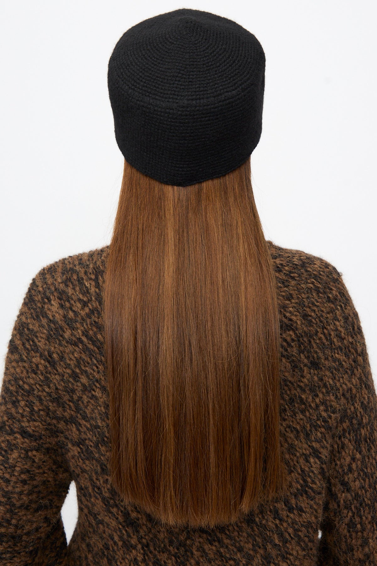 Back view of a person wearing a black merino wool Crochet Toque in Black.