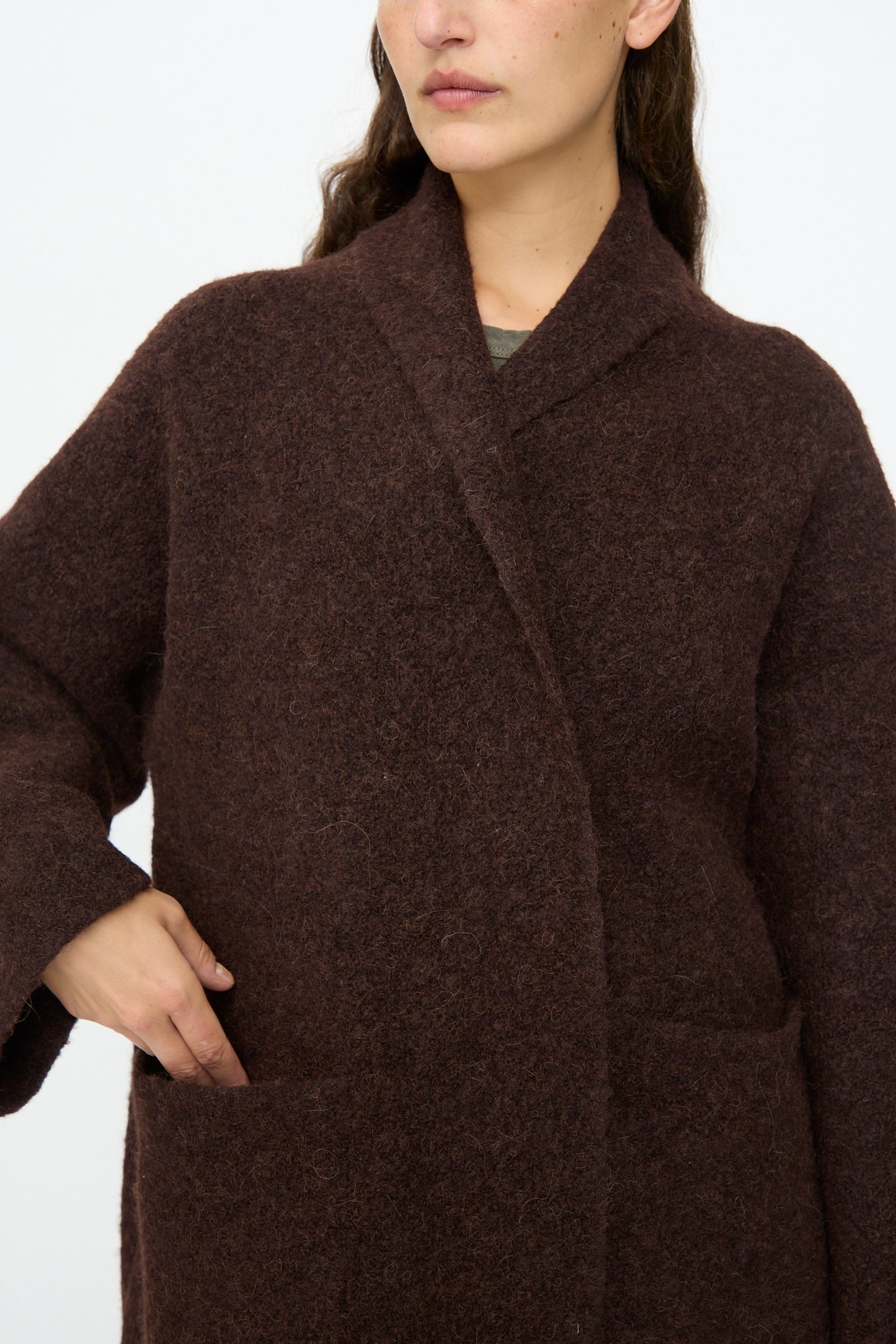 A person, shown from shoulders to waist, wears the Lauren Manoogian Double Face Long Coat in Merlot with their left hand resting in a pocket.