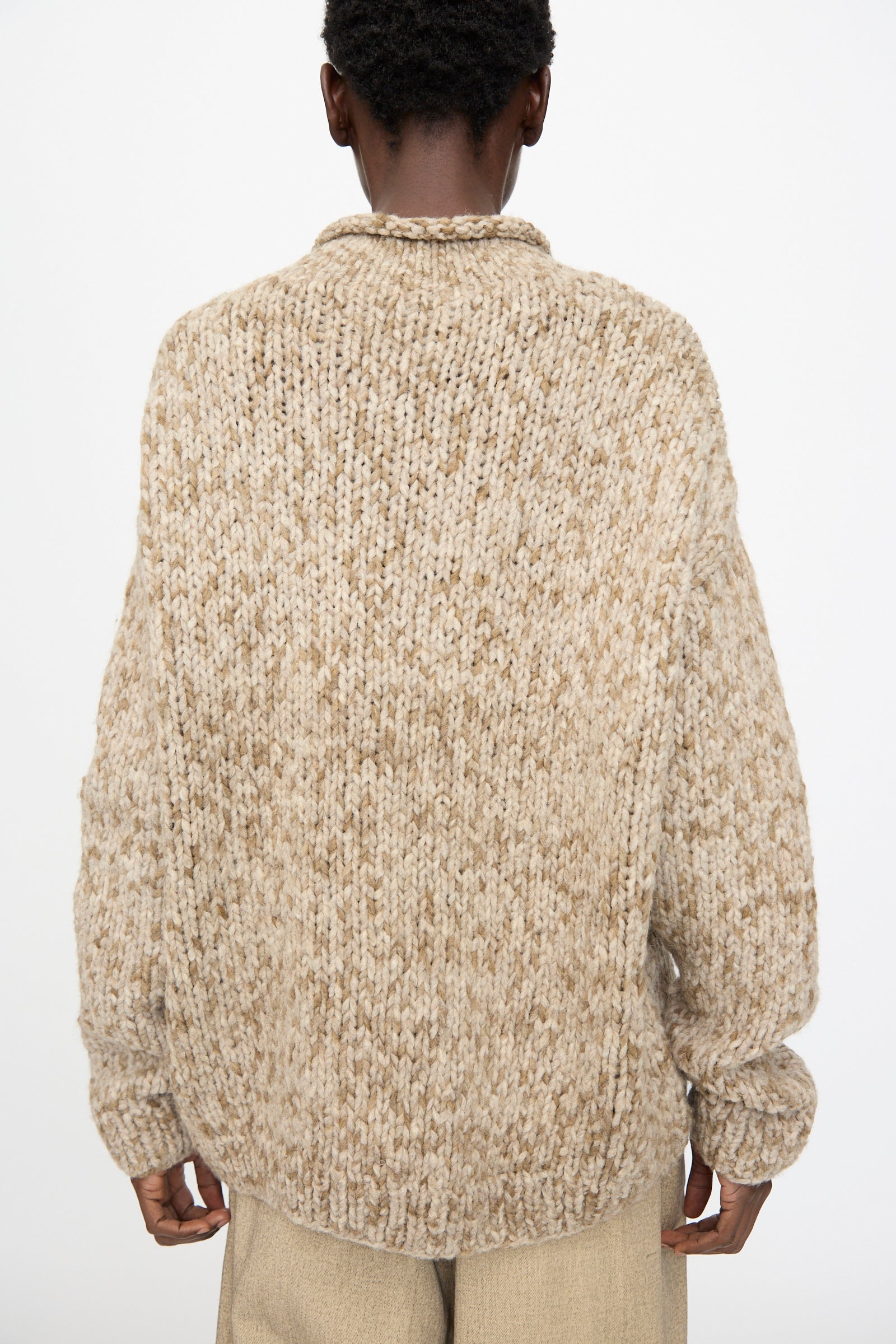A person wearing the Lauren Manoogian Handknit Paint Rollneck in Tobacco—shown from the back with light pants against a plain white background.
