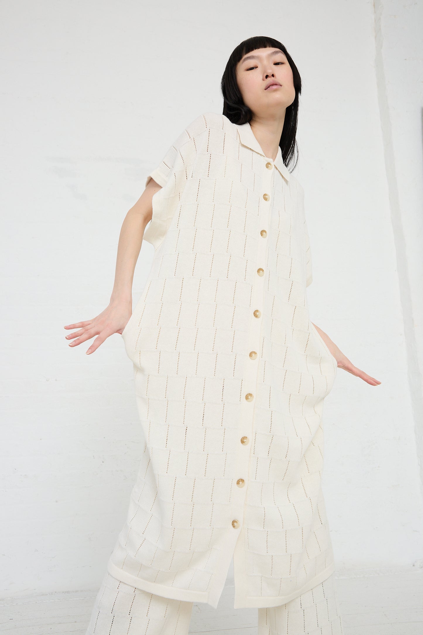 Woman posing in a Lattice Shirt Dress in Bone by Lauren Manoogian against a white background.