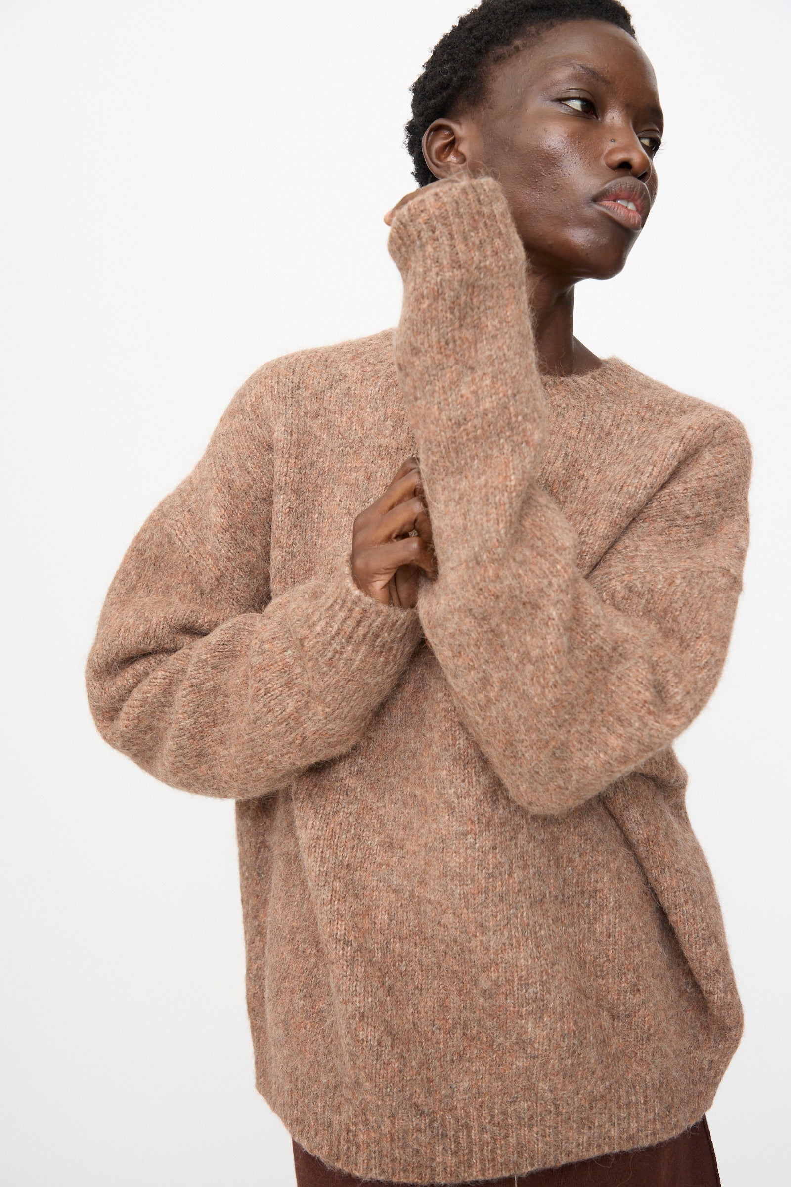 A person with short hair wears the Lauren Manoogian Loft Crewneck in Spice, standing against a plain light background.