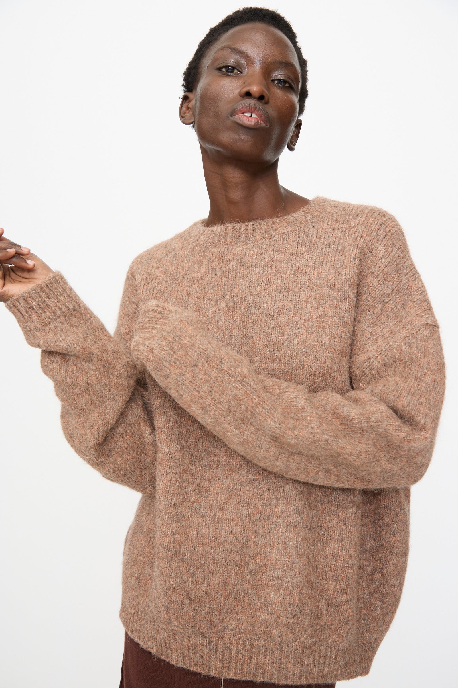 A person models the Lauren Manoogian Loft Crewneck in Spice, an oversized brown sweater, against a plain white background.