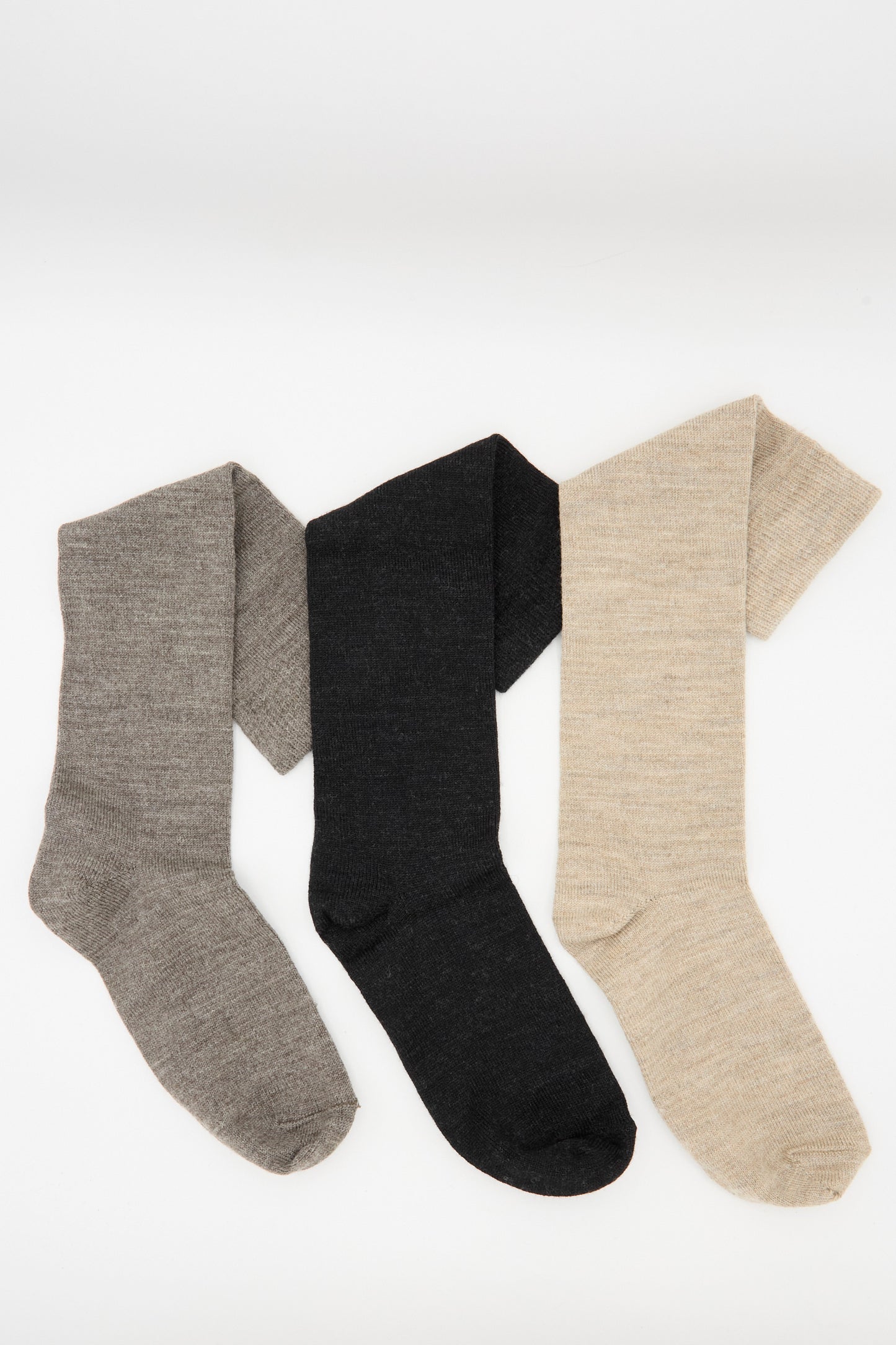 Three pairs of Lauren Manoogian's Sock Set in Mix, featuring mid-calf socks in gray, black, and beige, are arranged side by side on a plain white background.