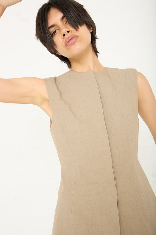 A woman is posing in an olive brown colored dress with a Structure Bodice by Lauren Manoogian. Front view.