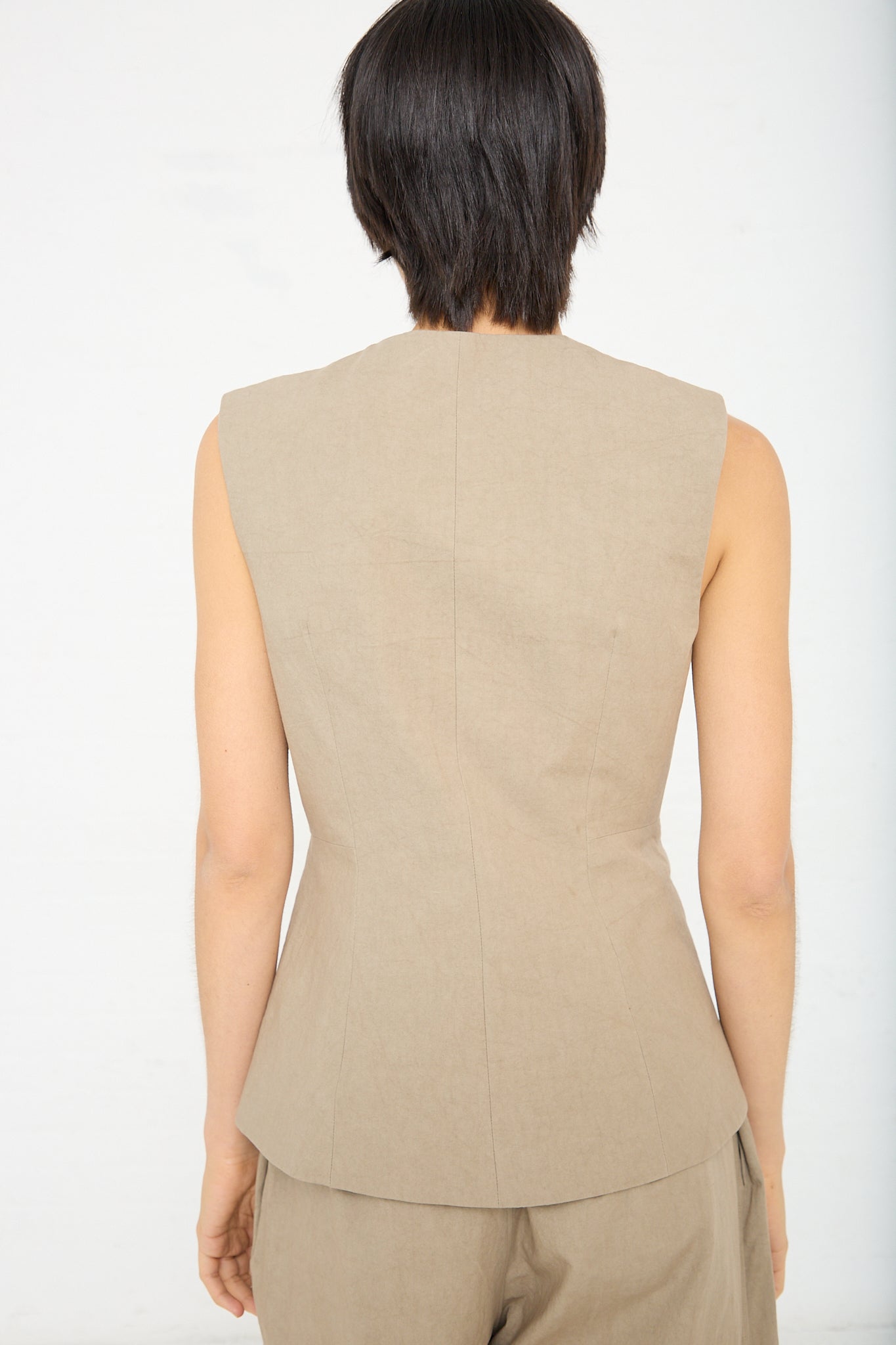The back view of a woman wearing a Lauren Manoogian Structure Bodice in Drab Olive brown), sleeveless top with matching pants.