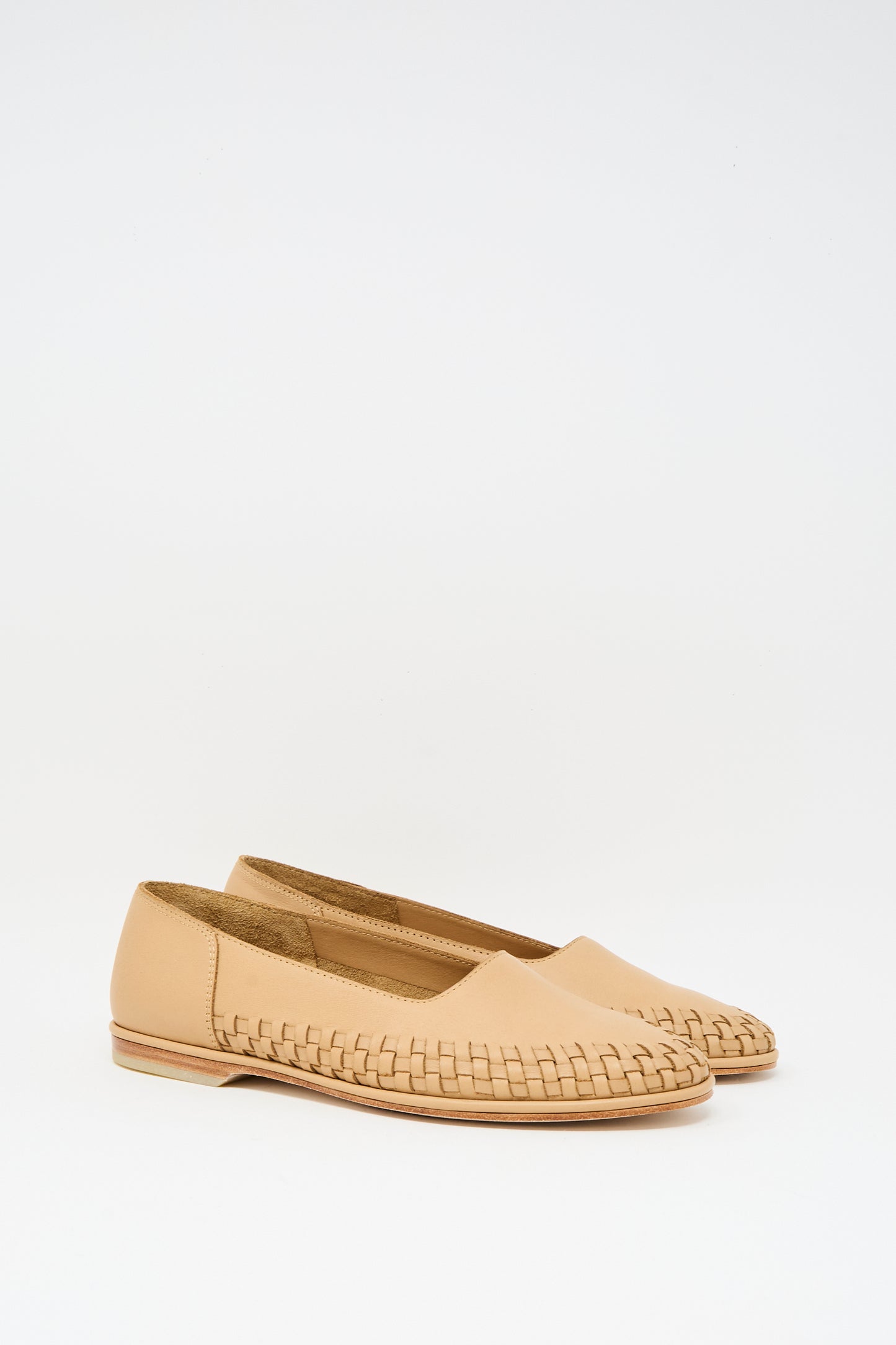 The Lauren Manoogian Weave Shoe in Natural features tan woven leather, a closed toe, and flat sole, displayed side by side on a plain white background.