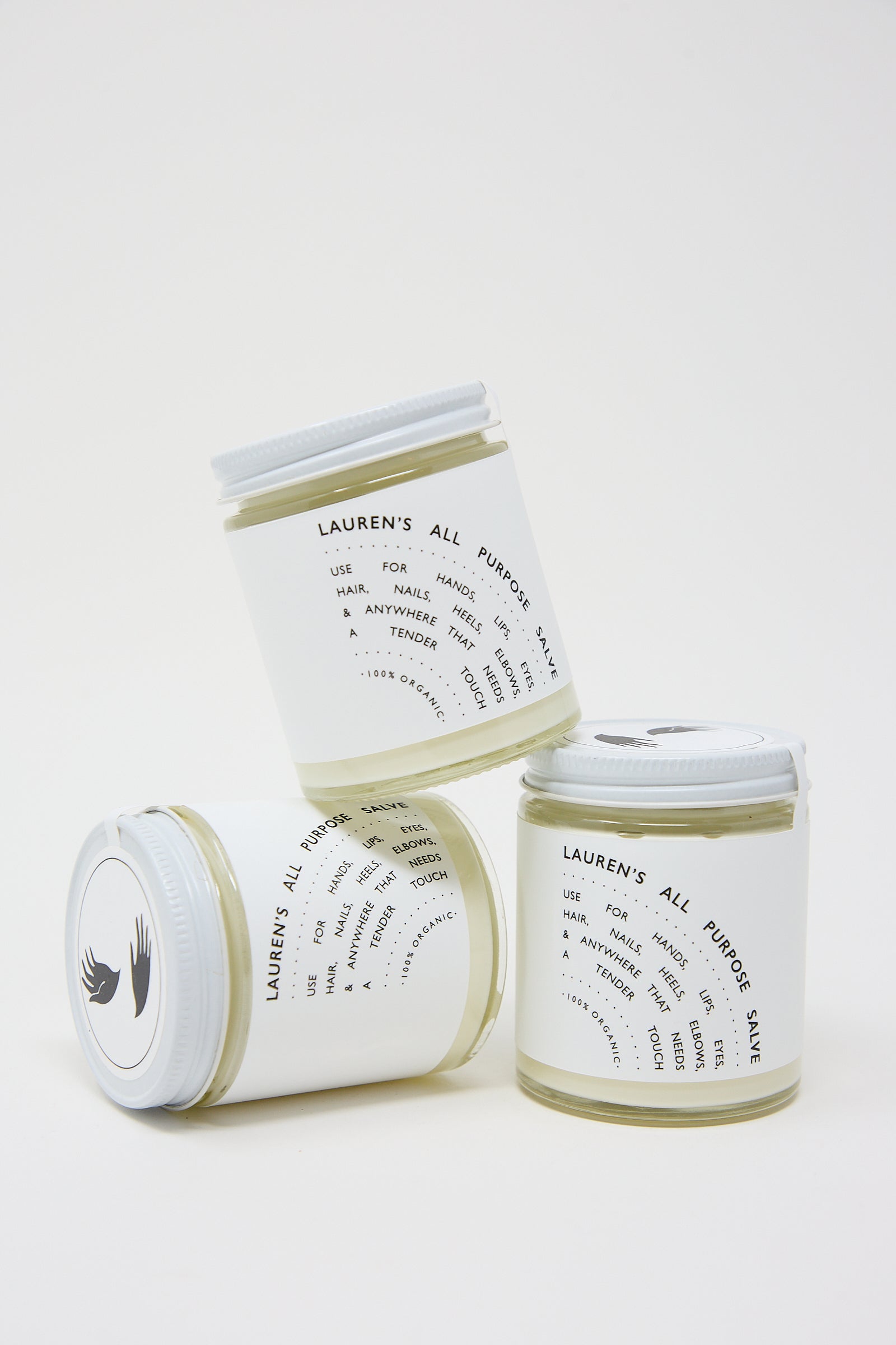 Three jars of "Lauren's All Purpose" salve with labels displaying organic ingredients and usage instructions, arranged against a white background.
