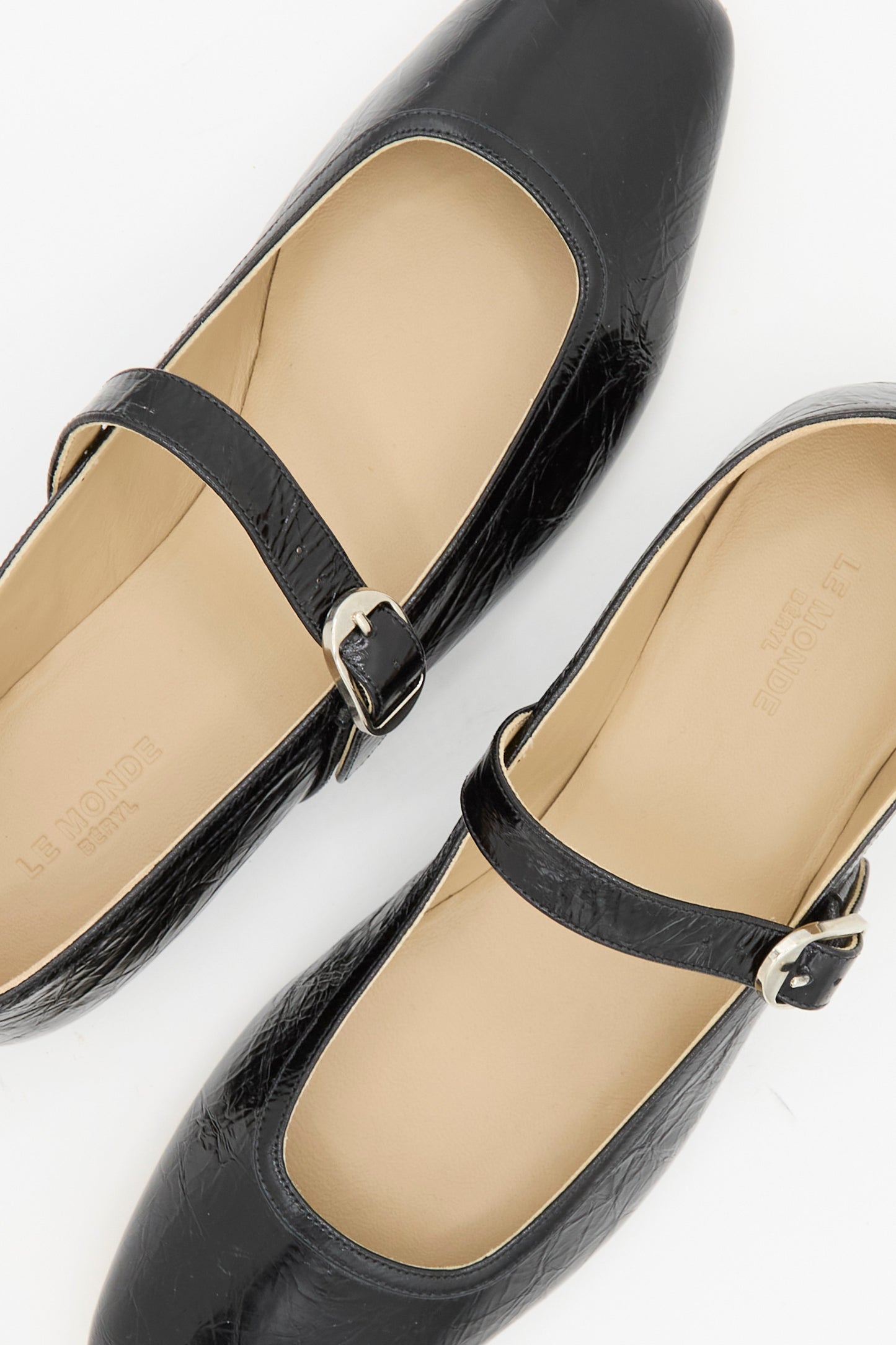 The Le Monde Beryl Ballet Mary Jane in Black features buckled straps, beige insoles, and lambskin leather, shown from above on a white background.