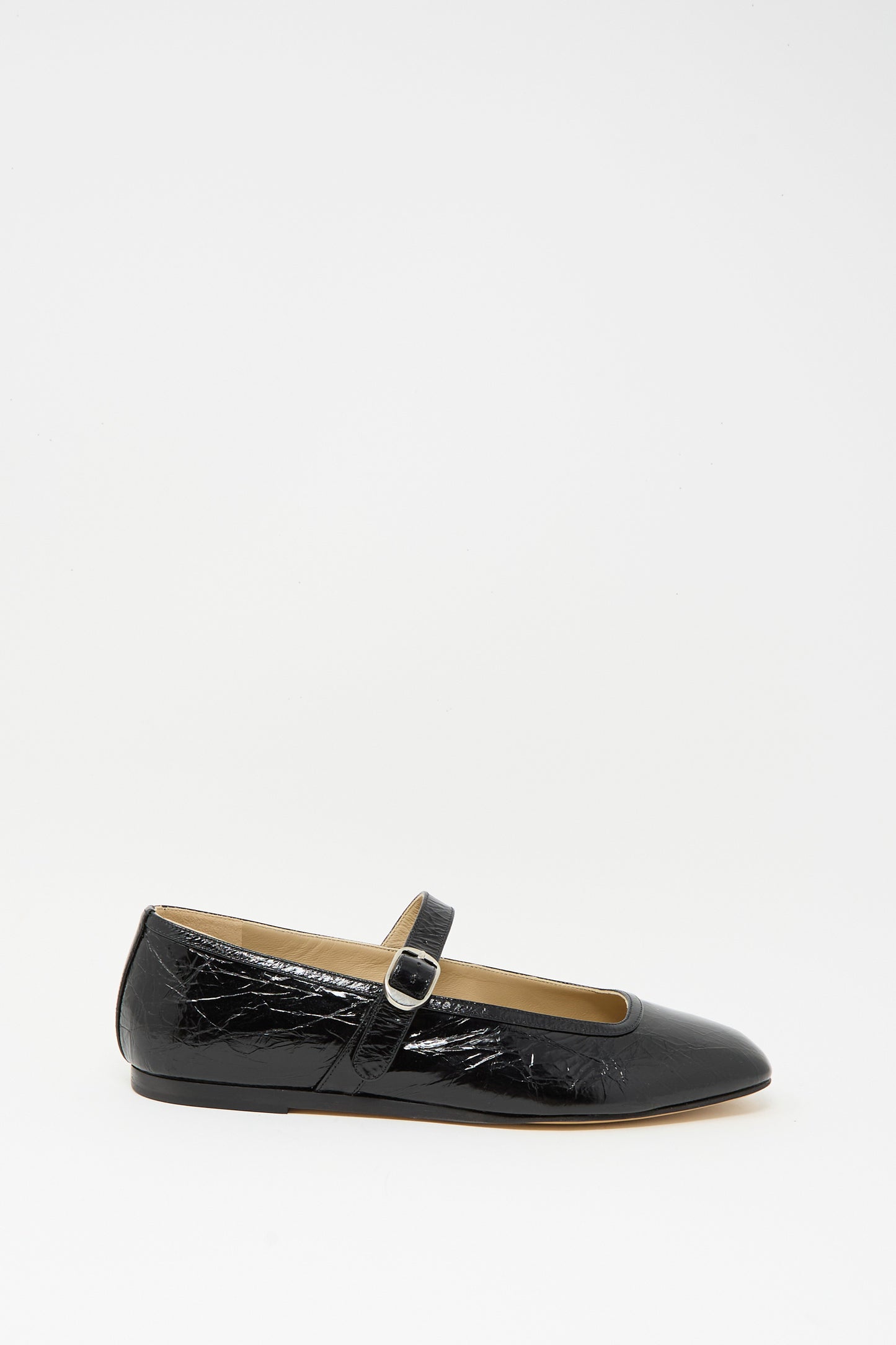 The Ballet Mary Jane in Black by Le Monde Beryl is a single flat shoe crafted from black patent lambskin leather, featuring a buckle strap, shown on a plain white background.