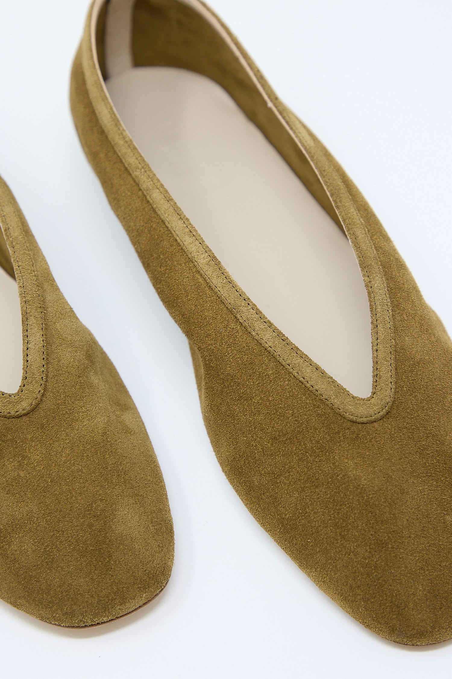 A pair of taupe suede Luna slippers from Le Monde Beryl on a white background. Up close.