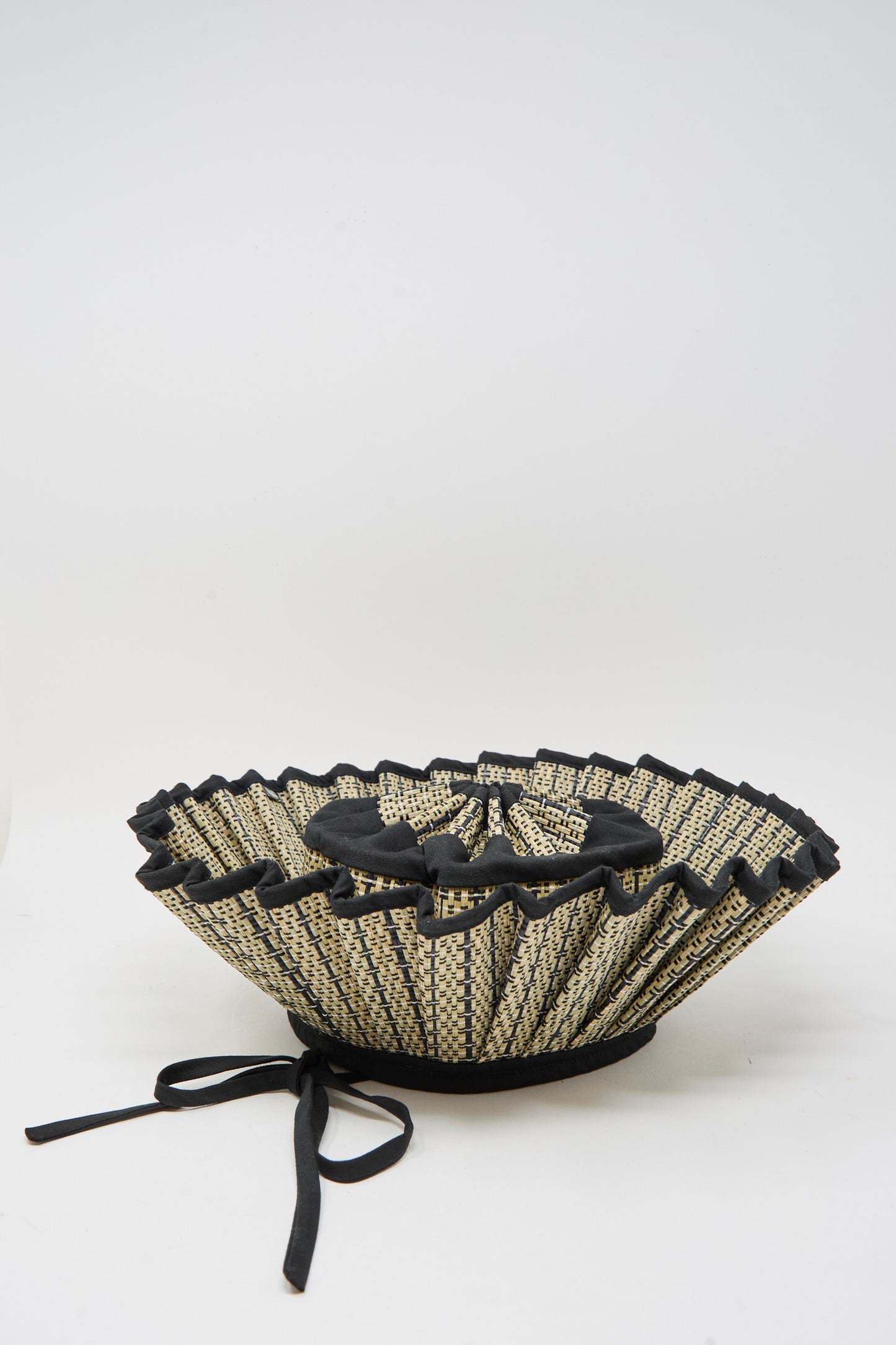 The Island Capri Maxi Hat in Lovers Point by Lorna Murray features natural grass fibers, a wide ruffled brim, black ribbon ties, and UPF 50+ protection. Shown on a plain white background.