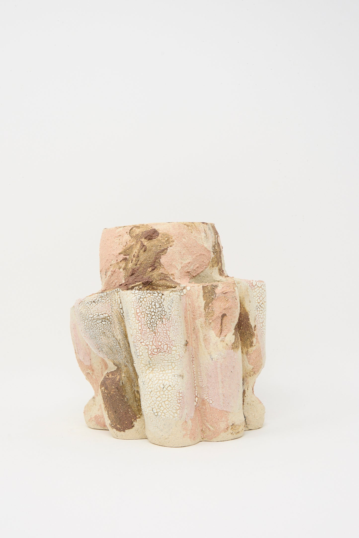 The Lost Quarry Hand Built Clay Tulipiere Vessel features a sculptural form with an irregular, textured surface in pink, beige, and brown tones, shown against a plain white background.