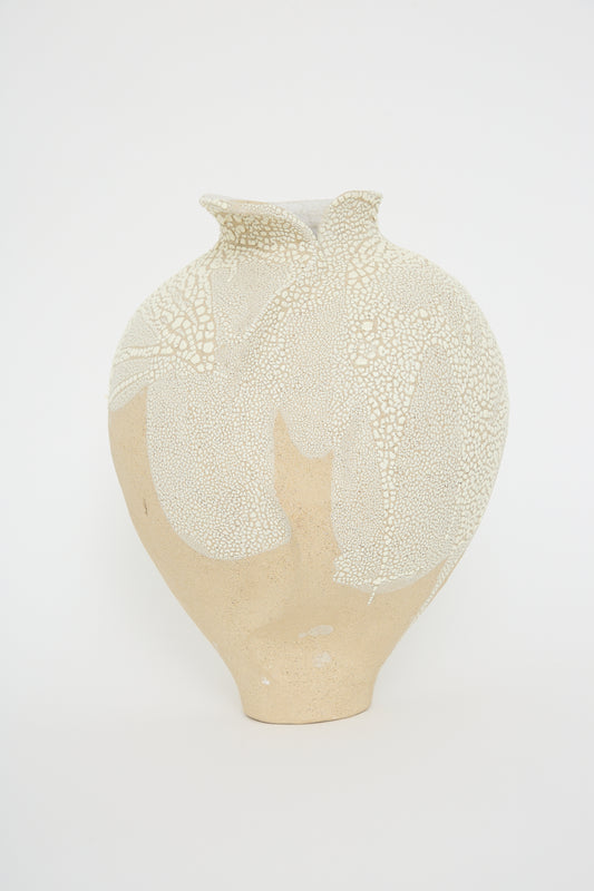 The Vessel No. 741 in White Sculpture Clay by Lost Quarry is a hand-built beige ceramic vase with a wide body and narrow neck, featuring a textured white pattern reminiscent of cracked paint on its upper portion. The background is plain white.