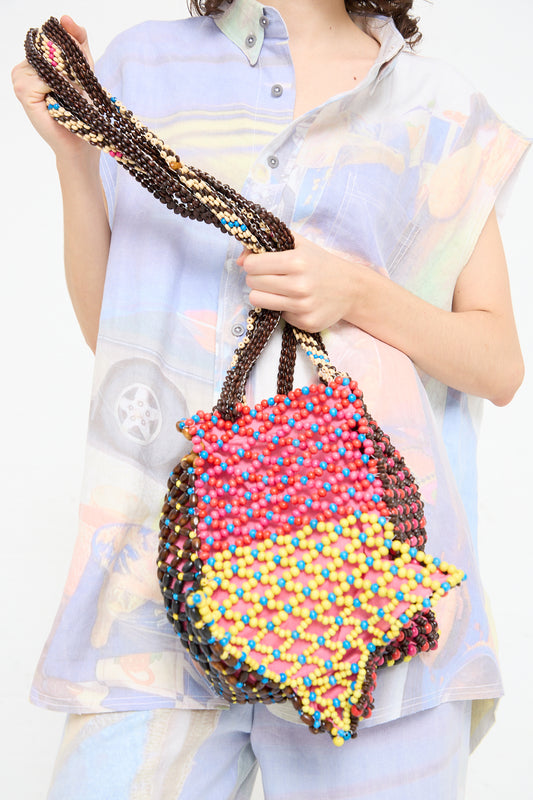 A woman is holding a Luna Del Pinal Assorted Beads Hectic Long Strap Bag in Multi Noise.