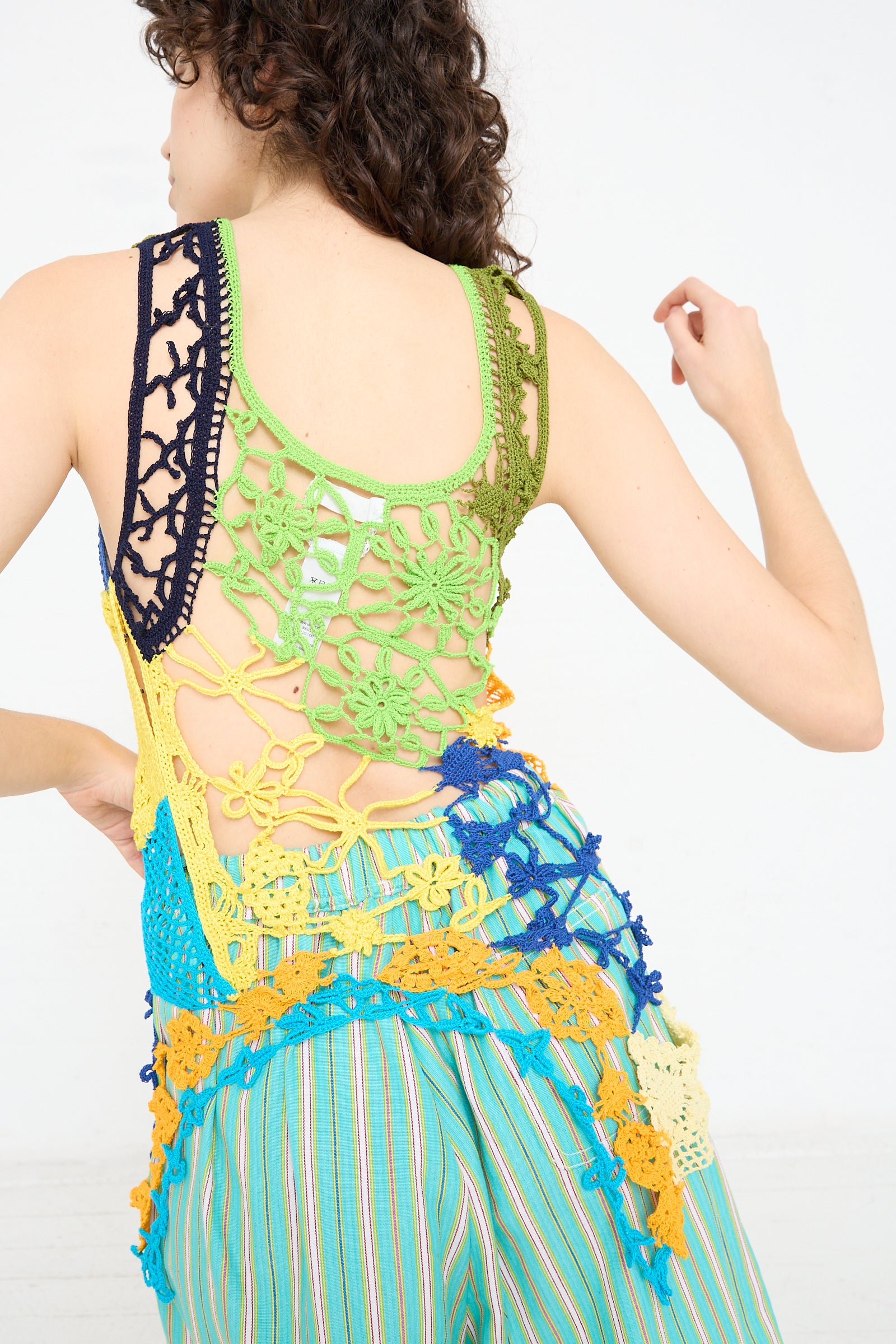The back of a woman wearing a Luna Del Pinal Labor De Retazos Crochet Mini Dress in Multi Noise.