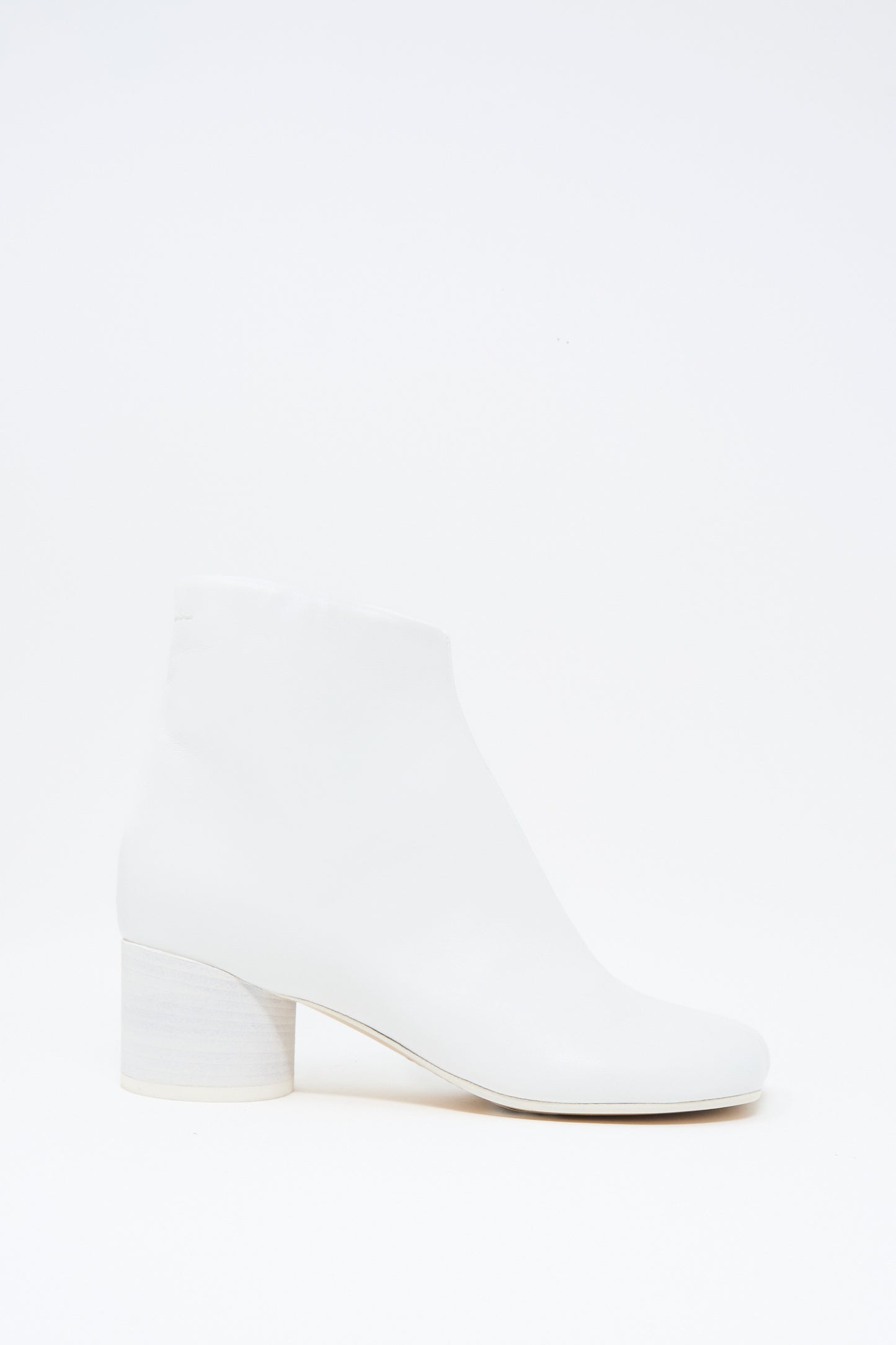 The MM6 Ankle Boot in White features buffed calfskin leather, a rounded toe, and a low chunky heel, shown against a plain white background.