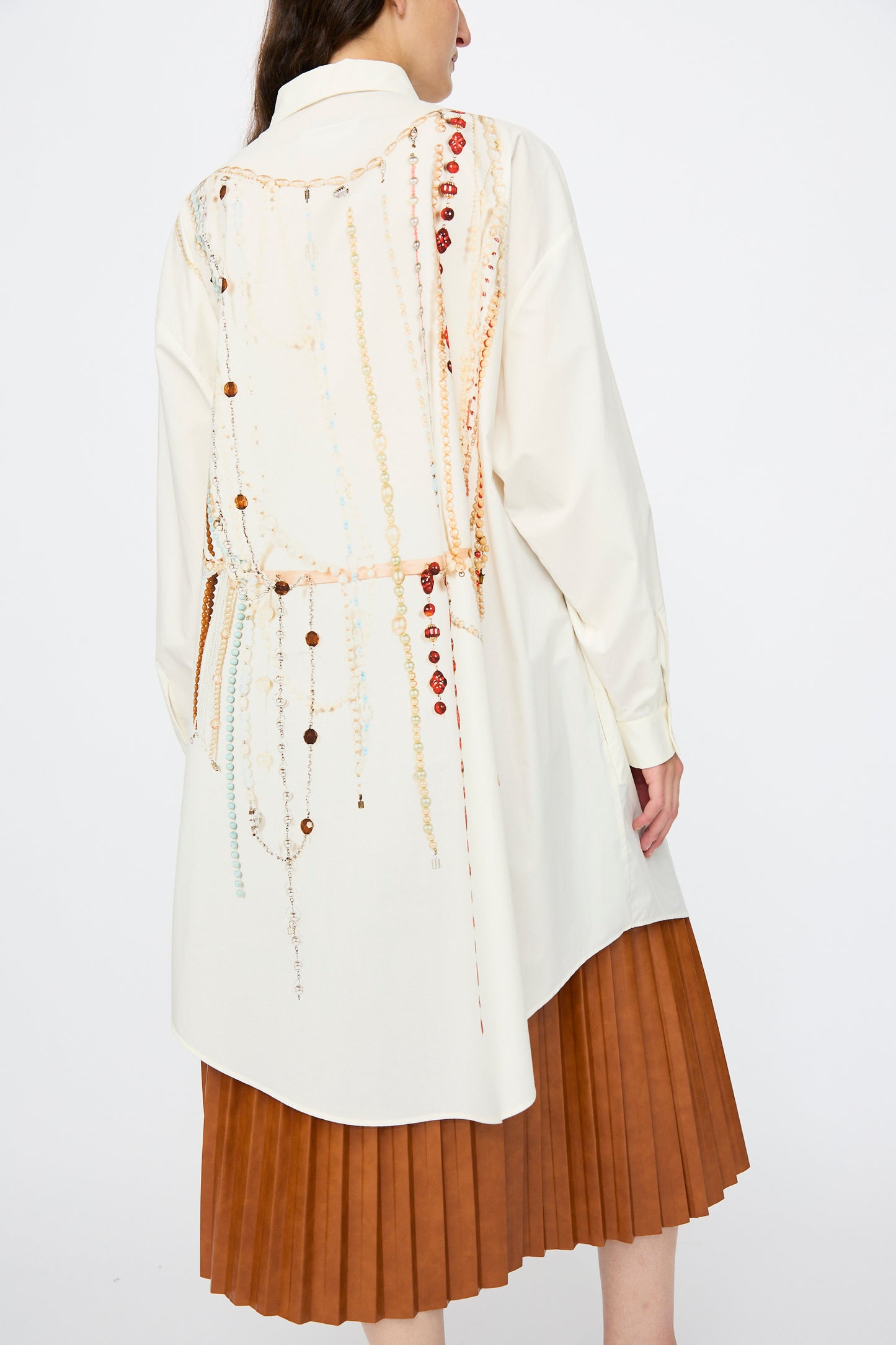 A person wearing the MM6 Dress in Pearls Print styled with a pleated brown skirt.