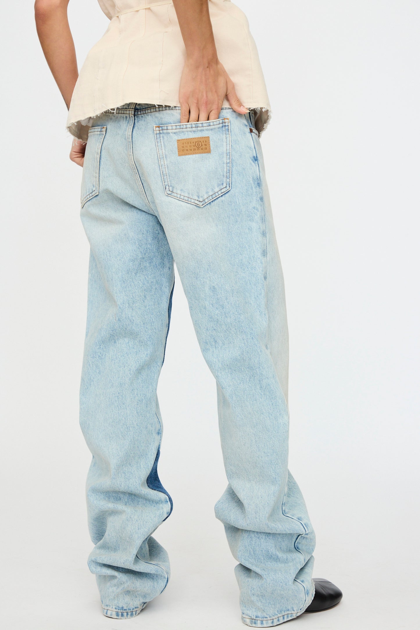 Someone in Pants 5 Pockets by MM6, relaxed fit and light blue with a classic design, pairs them with a beige top against a plain background.