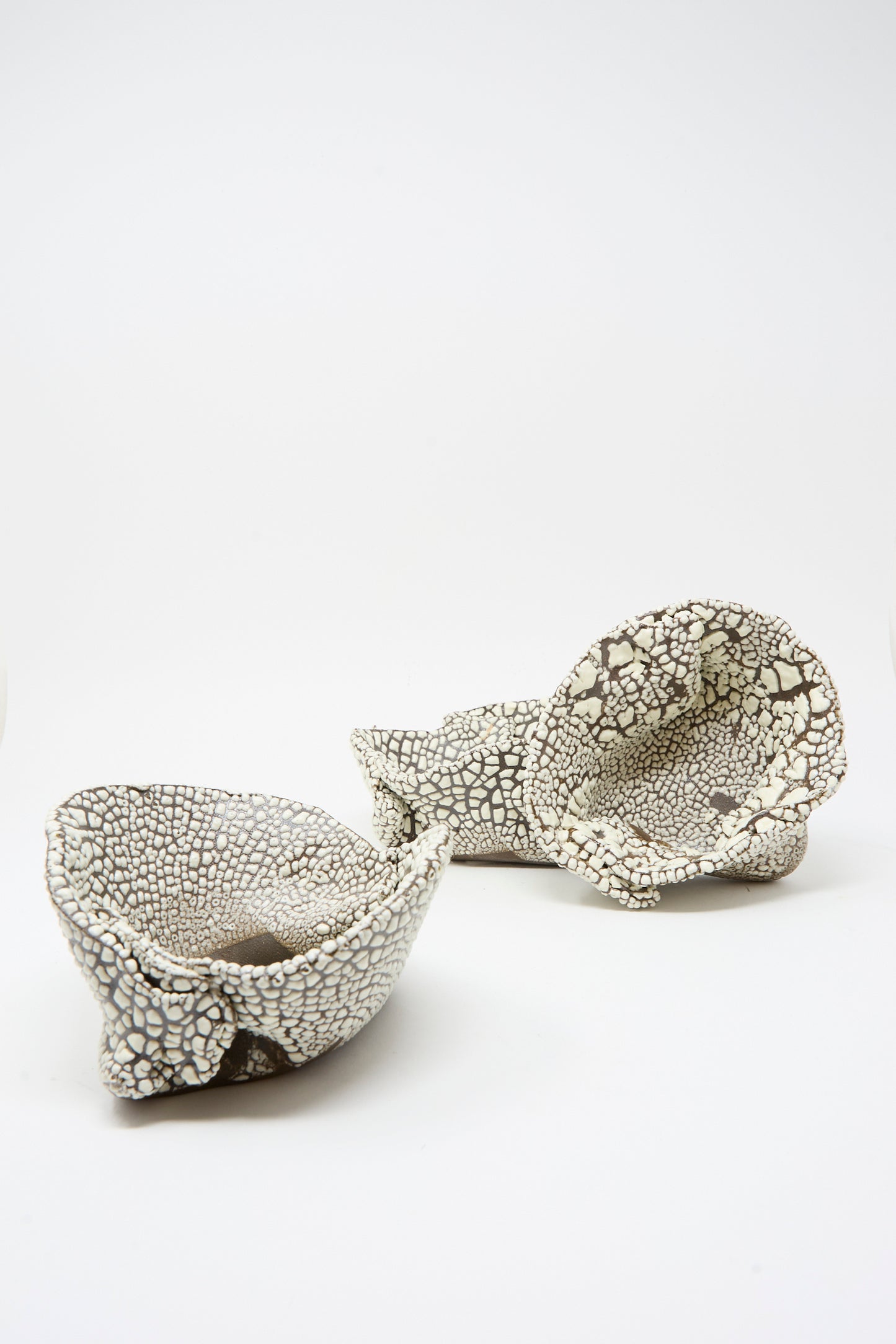 The MONDAYS Folded Wavy Bowl in Crawl II features abstract, textured ceramic design with a crawling white glaze, artfully displayed on a plain white background and inspired by hand-built Brooklyn bowls.