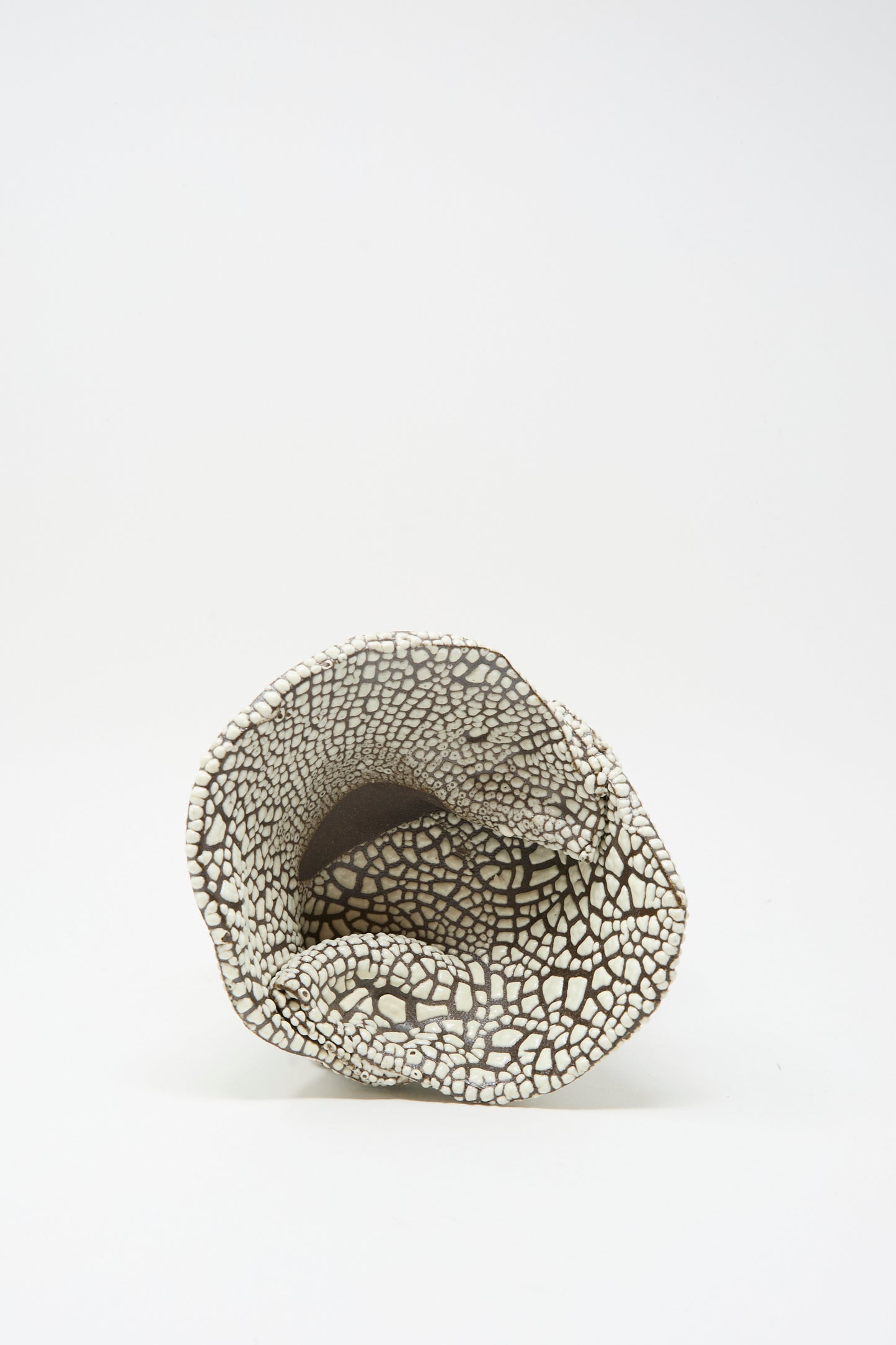 The MONDAYS Folded Wavy Bowl in Crawl III is a hand-built ceramic piece from Brooklyn, featuring an irregular rim and black-and-white cracked pattern beneath a subtle white glaze, shown on a plain white background.