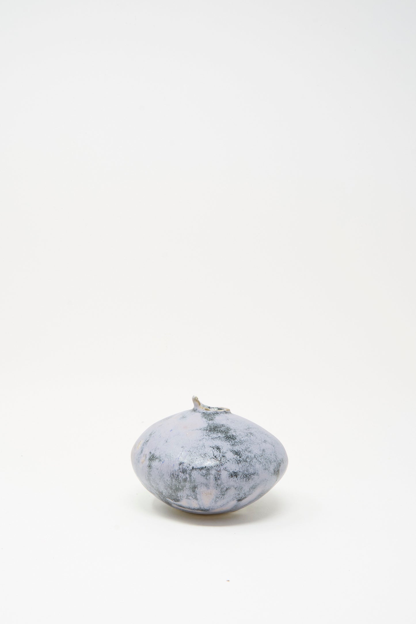 The MONDAYS Mini Moon Vase in Blue is a round, grayish-blue handmade stoneware vase with a short stem, shown on a plain white background.