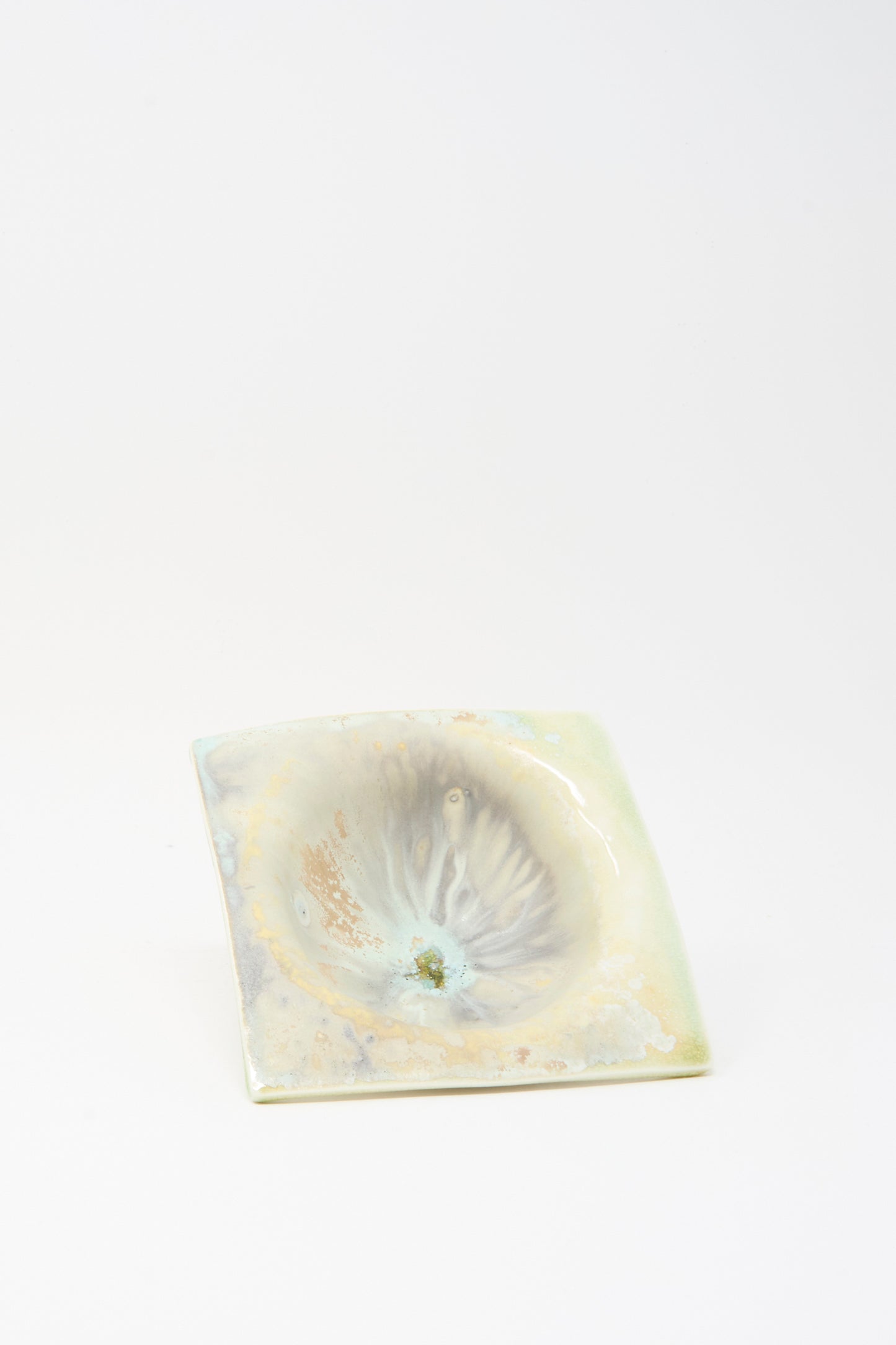 The MONDAYS Soda-Fired Porcelain Square Bambi Bowl is a small, square bowl with a marbled pale glaze and a shallow, uneven center depression.