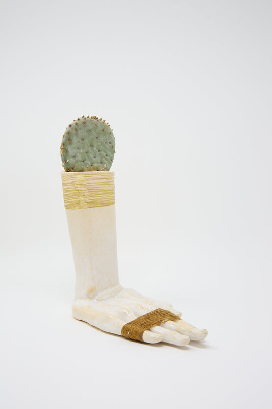 A Ceramic Hand Sculpture with Gold and Brown Thread, made by Monty J and holding a small round cactus.