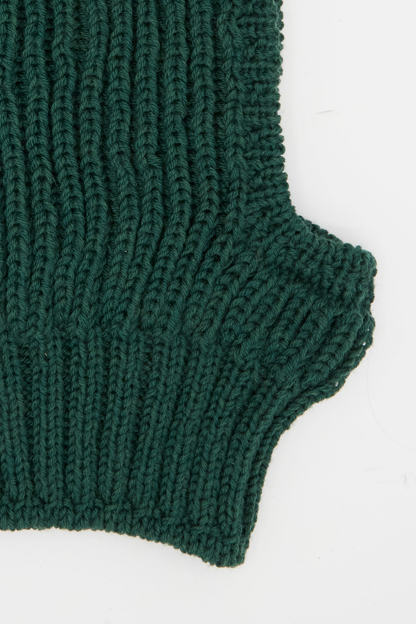 Close-up of the Wool Balaclava Lina in Emerald by Maria La Rosa, made in Italy, featuring fine green rib knit wool with a protruding rectangular edge against a white background.