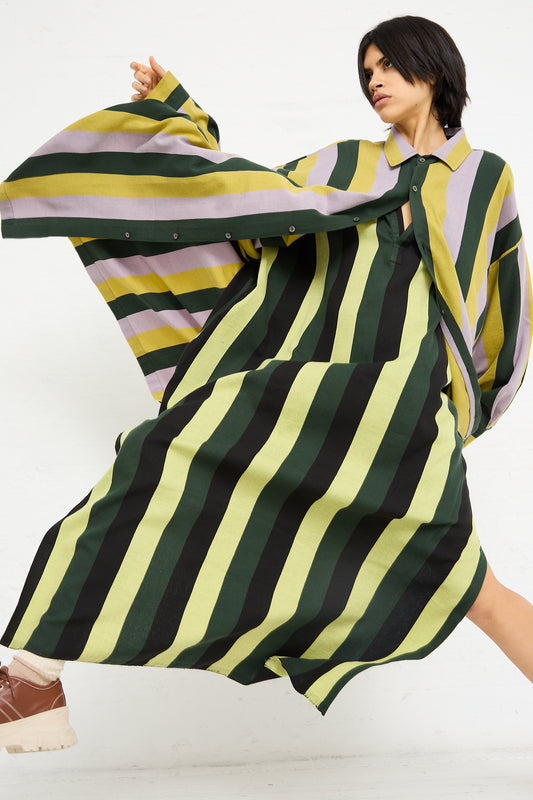 Woman posing in a Marrakshi Life Small Collar Oversized Shirt in Stripe designed with flowing stripes, evoking traditional Moroccan wardrobe elements, against a white background.