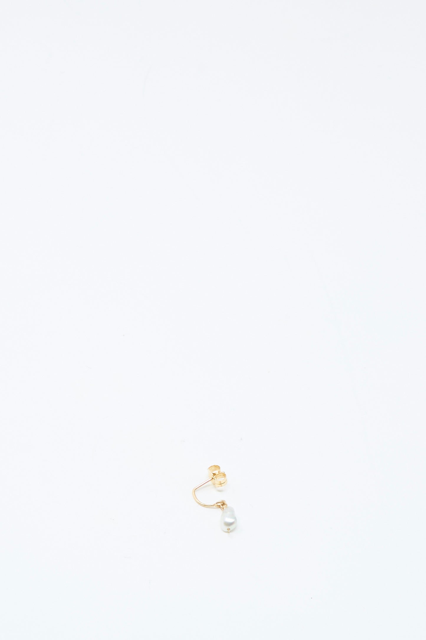 The Mary MacGill 14K Crescent Charm Single Earring in Keshi Pearl features a 14k gold hoop with a small white Keshi pearl attached, displayed near the bottom center of a plain white background.