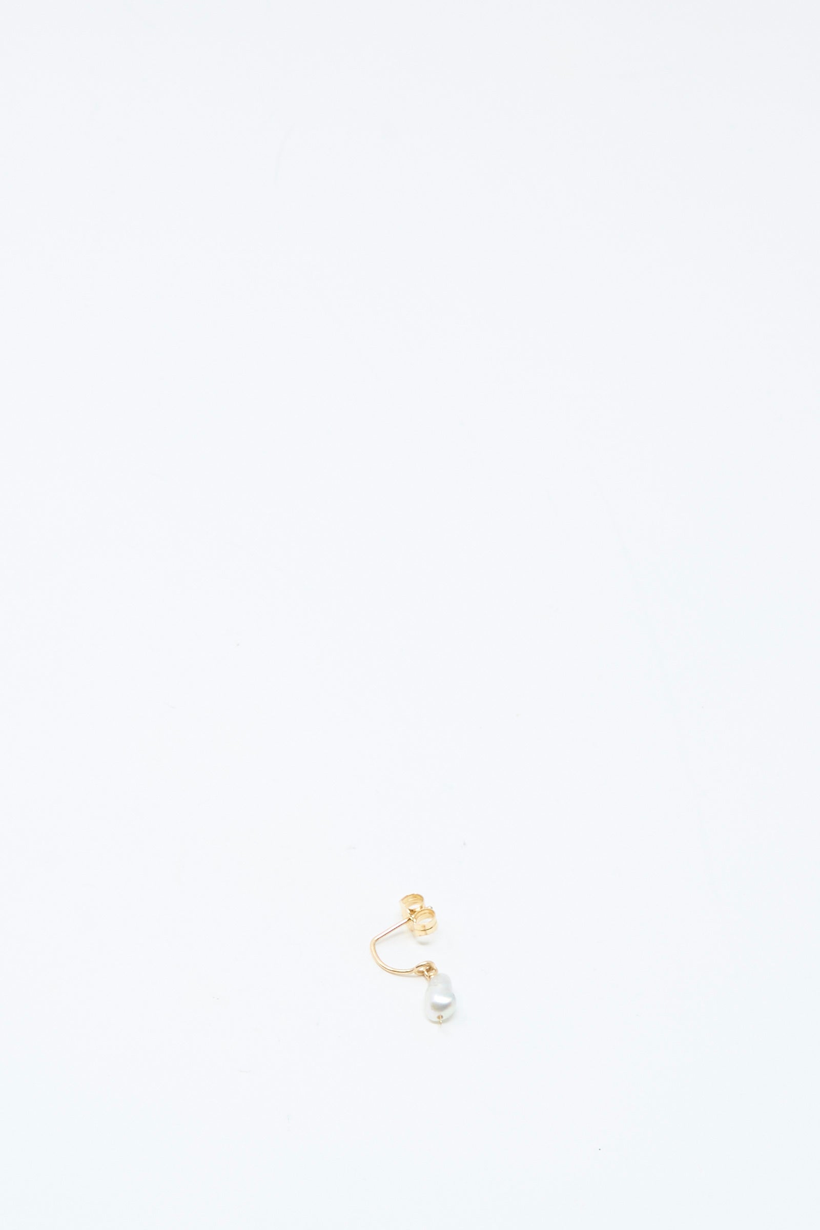The Mary MacGill 14K Crescent Charm Single Earring in Keshi Pearl features a 14k gold hoop with a small white Keshi pearl attached, displayed near the bottom center of a plain white background.