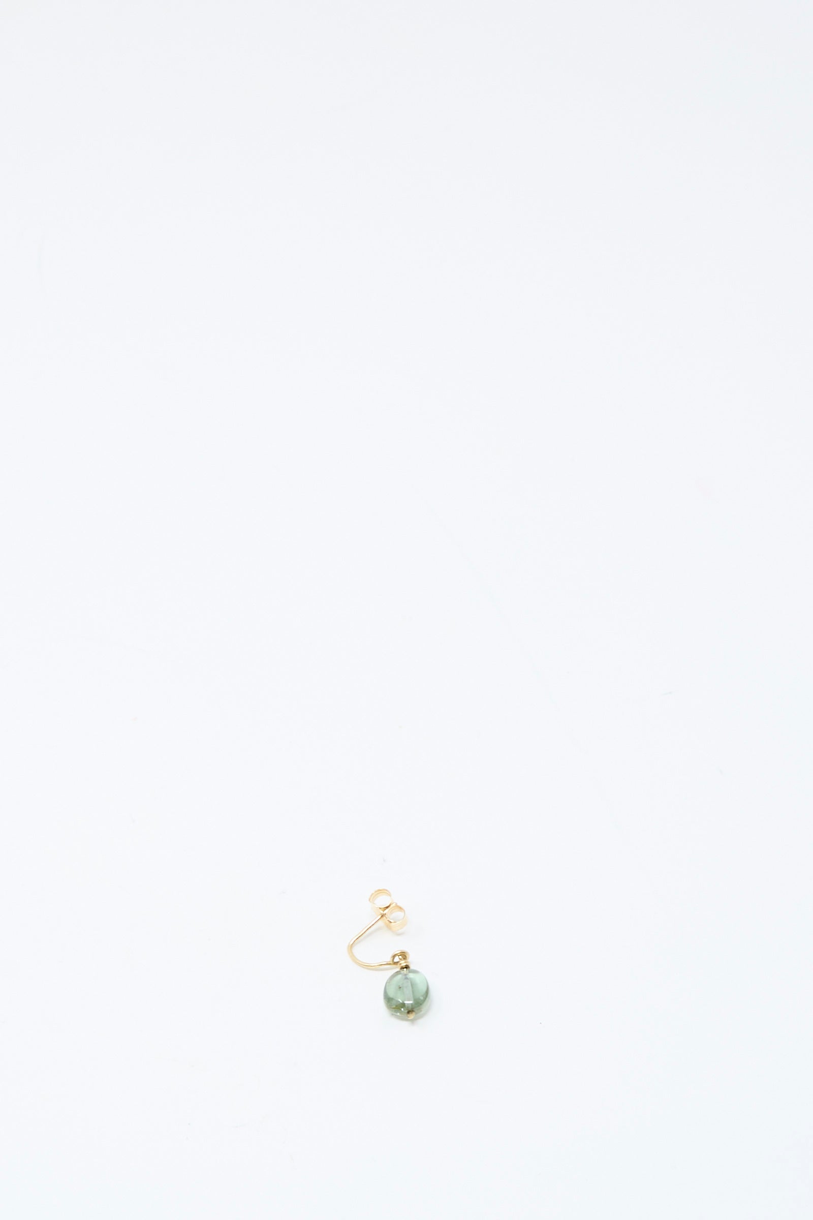 The Mary MacGill 14K Crescent Charm Single Earring in Round Tourmaline is a handmade gold hoop featuring a green tourmaline bead, centered near the bottom of a plain white background.