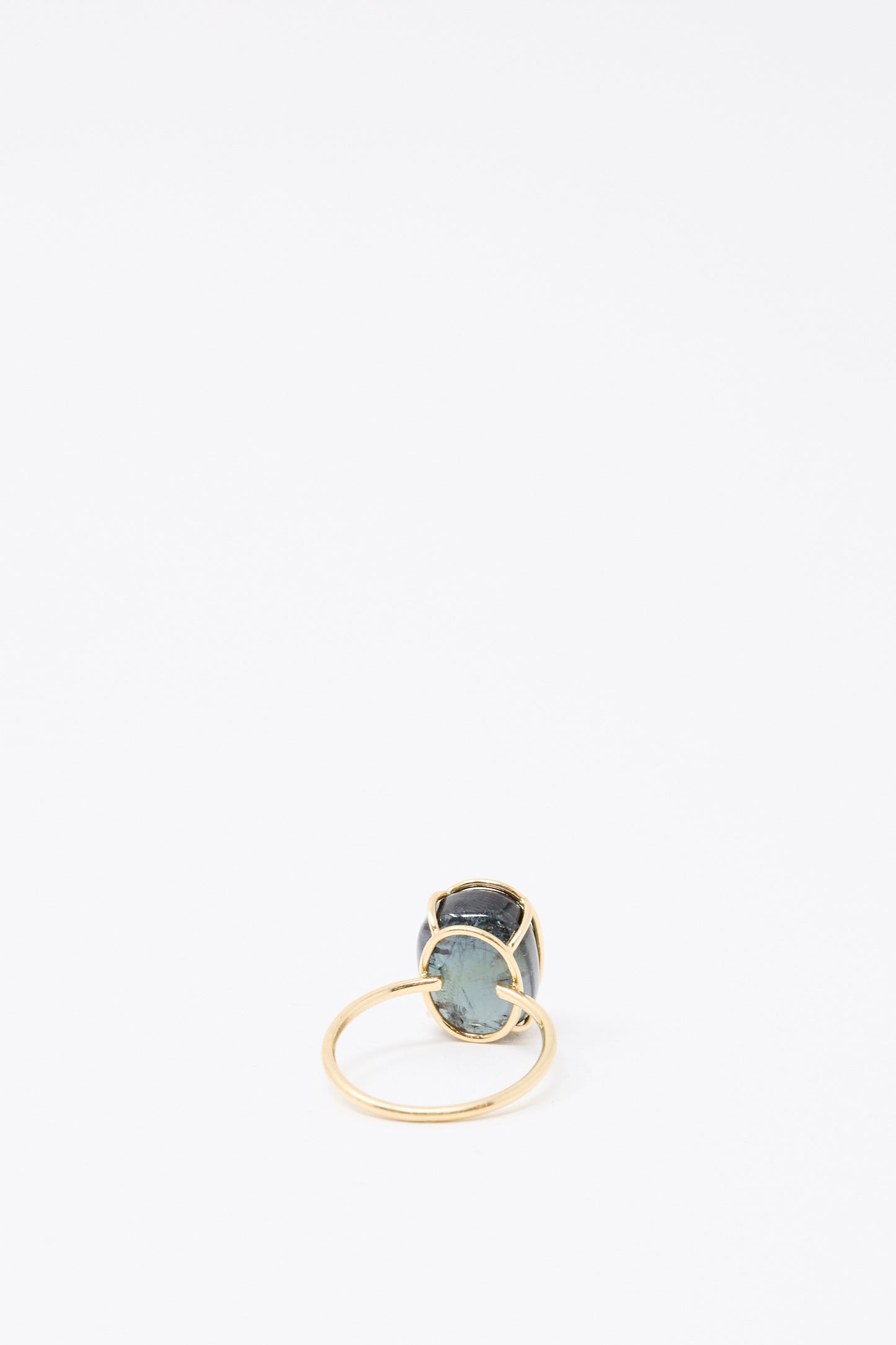 The Mary MacGill 14K Floating Ring in Green Tourmaline, a handmade gold ring featuring an oval green tourmaline stone, is displayed upright on a plain white background.