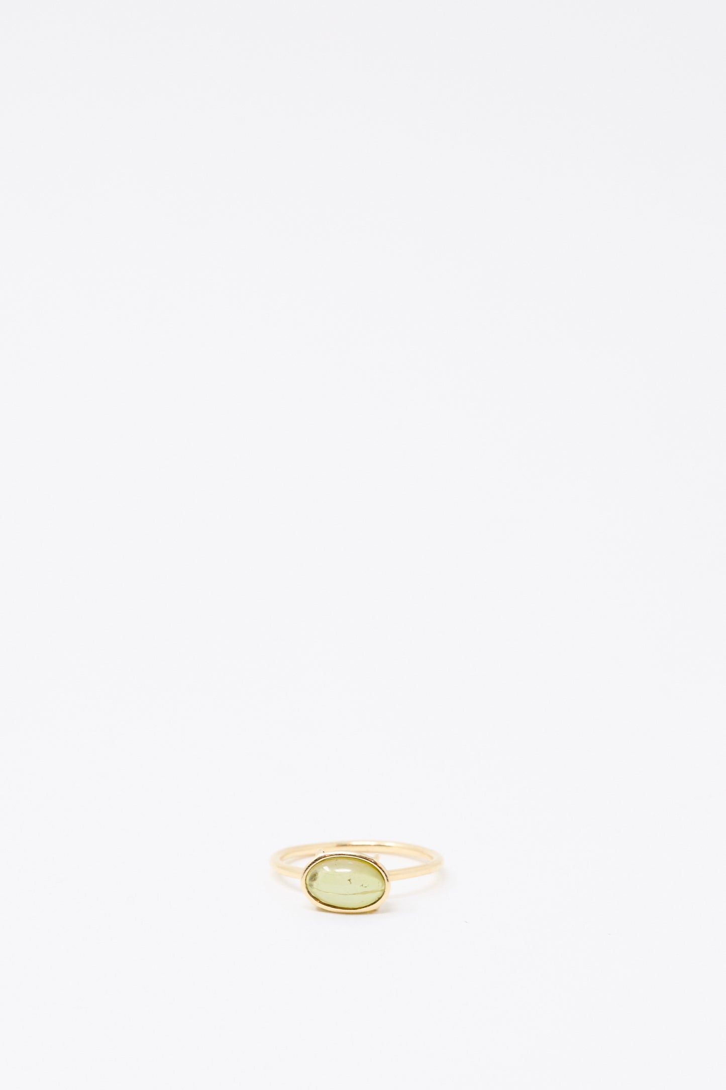 The Mary MacGill 14K Floating Ring in Petite Green Tourmaline features a delicate gold band and an oval green tourmaline stone, displayed on a plain white background.