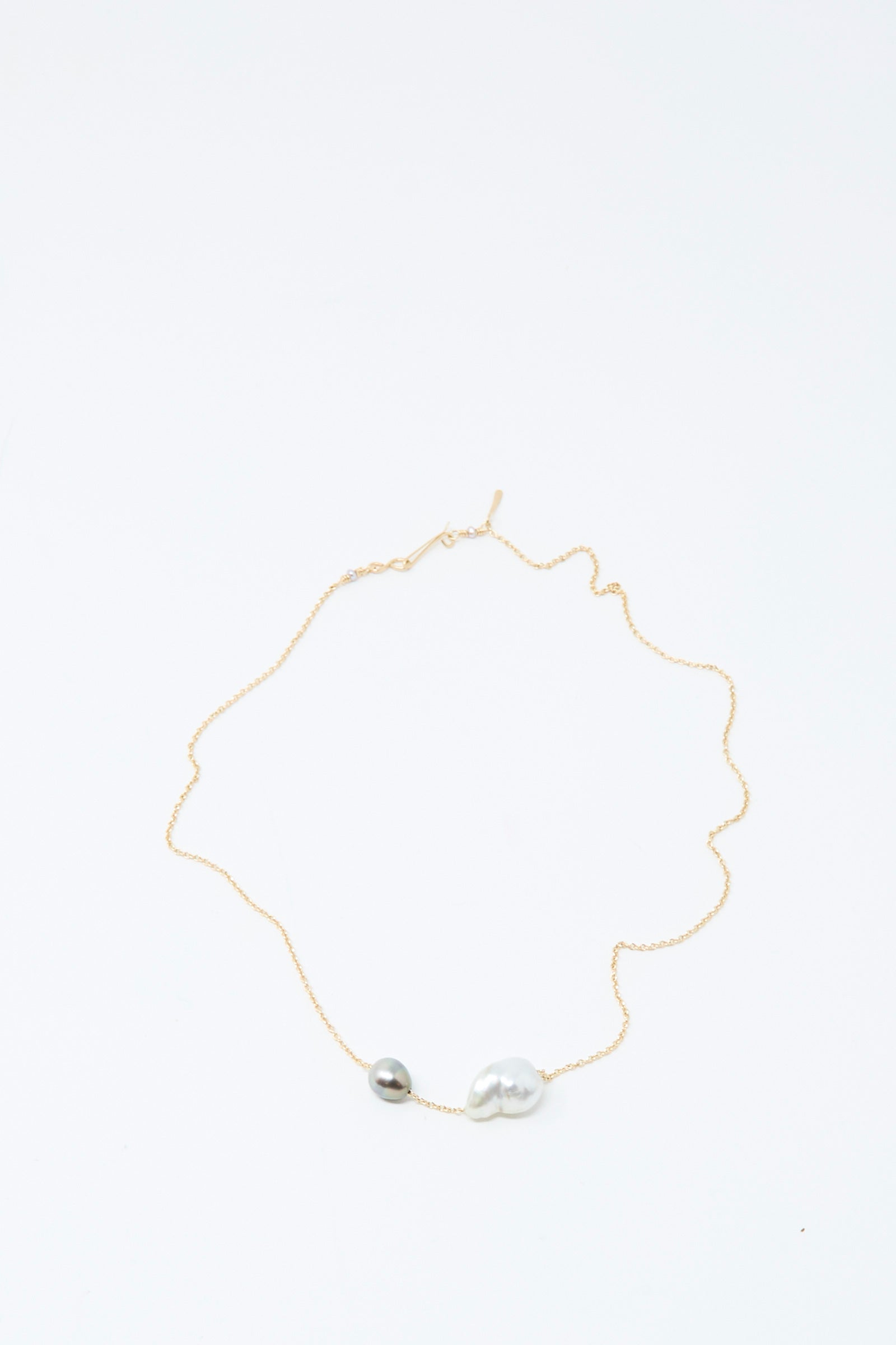 The Mary MacGill 14K Necklace in White Keshi and Silver Tahitian Pearl features a delicate gold chain with one small round silver bead and one larger, irregular bead, and shown on a white background.