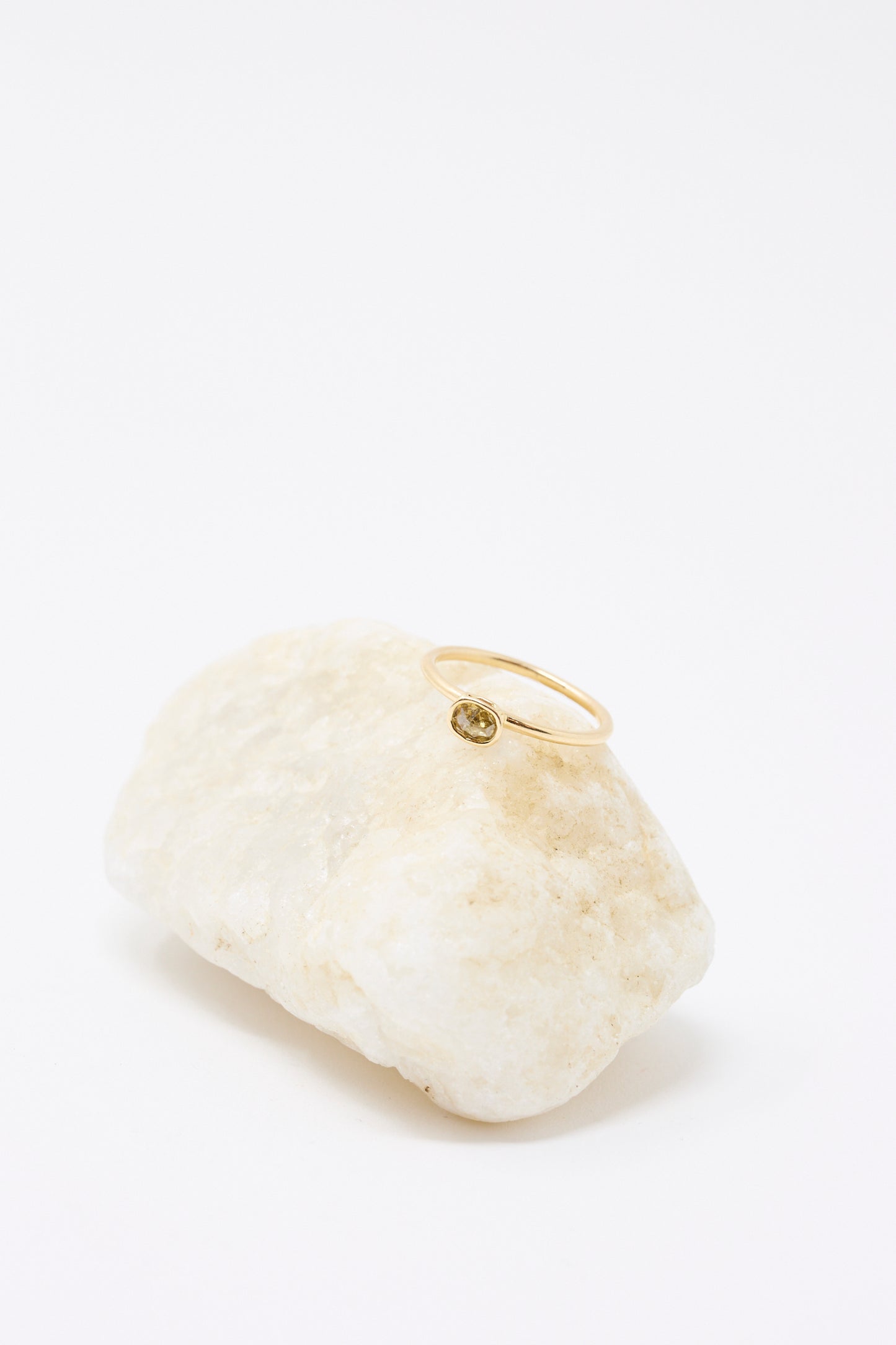 The Mary MacGill 14K Floating Ring features a cognac rose cut mineral diamond, displayed on a light-colored rock against a white background.