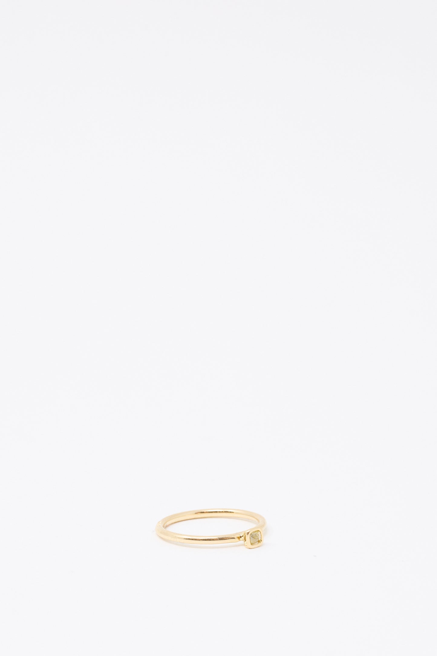 The Mary MacGill 14K Floating Ring in Petite Light Green Rose Cut Mineral Diamond features a slim gold band with a petite, square setting and light green diamond, placed near the bottom center of a plain white background.