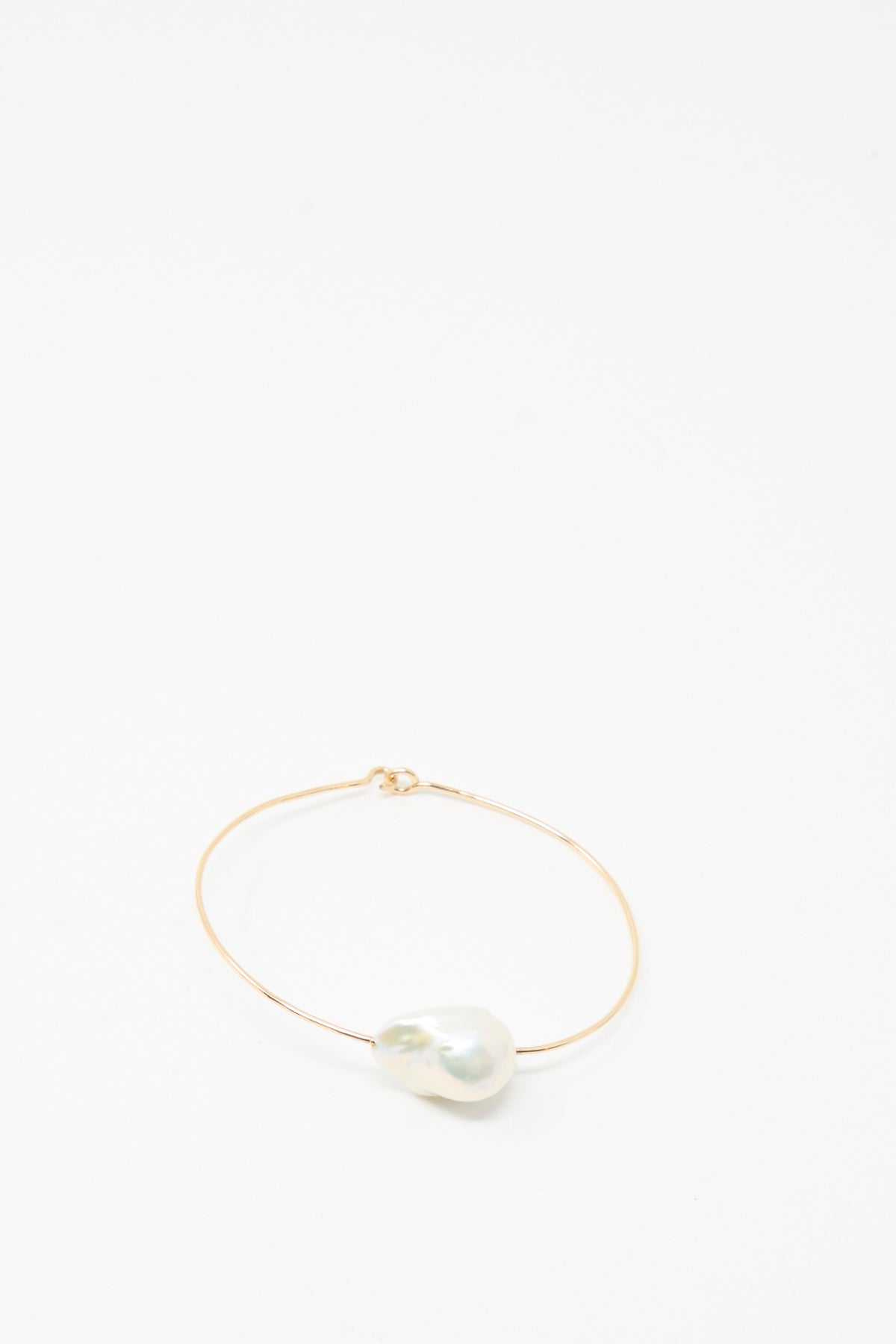 The Mary MacGill Baroque Pearl Cuff Bracelet in White features a thin gold-filled cuff with a large white Baroque pearl, shown on a plain white background.