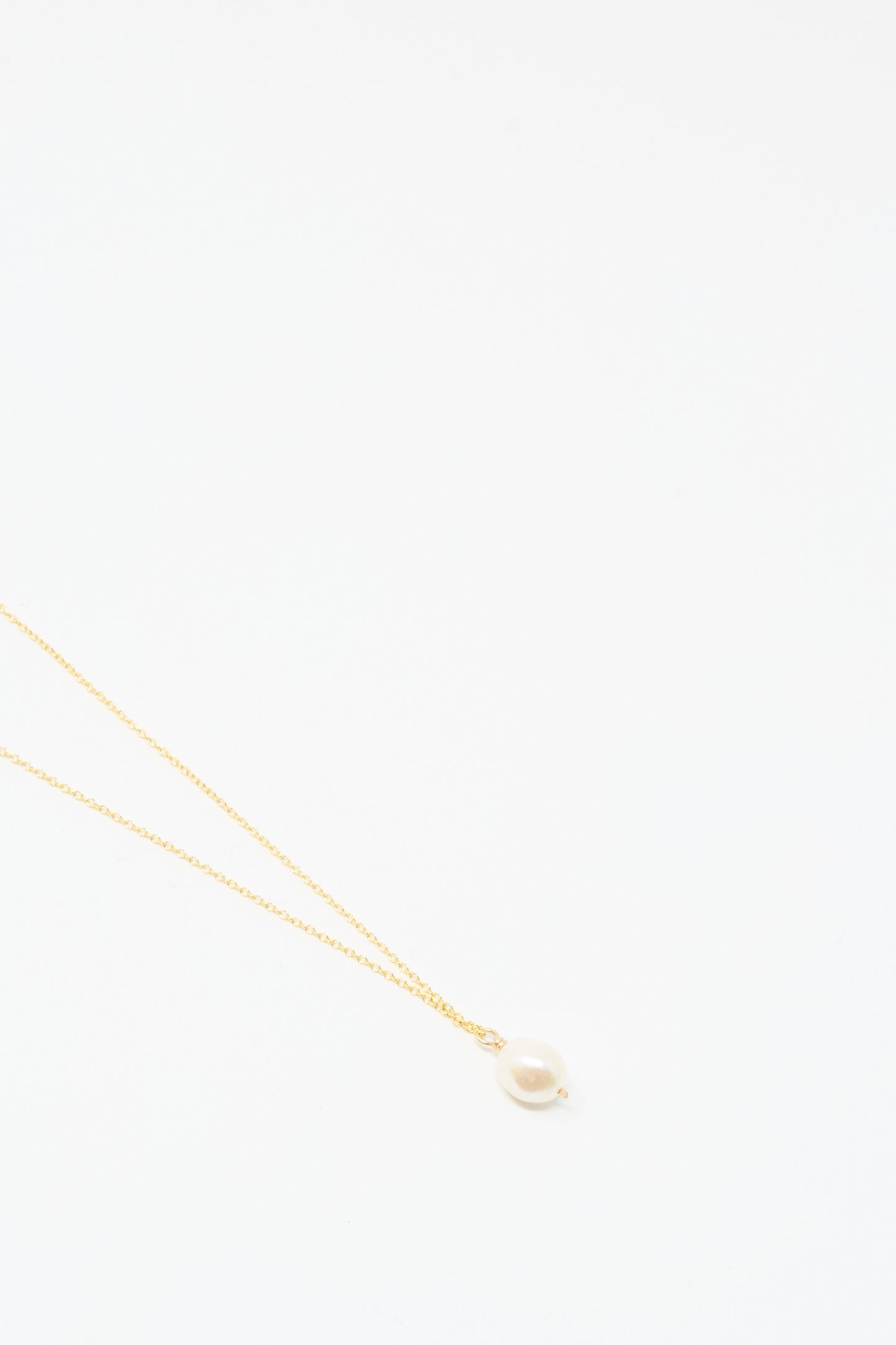 The Mary MacGill Baroque Pearl Drop Necklace in White, 18", features a handmade gold chain with a single baroque pearl pendant, shown on a simple white background.