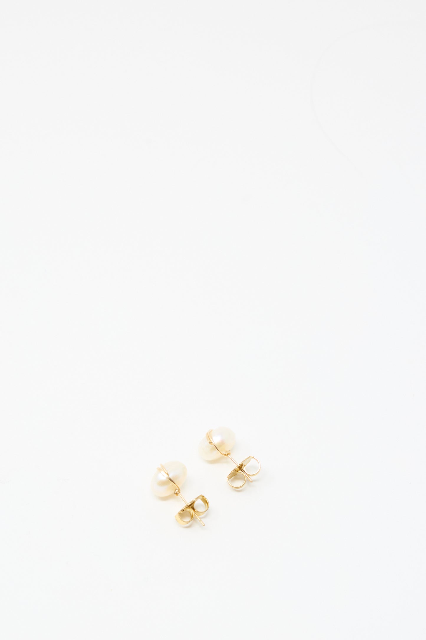The Grande Baroque Pearl Studs in White by Mary MacGill are handmade gold-filled wire earrings featuring small white pearls, shown on a plain white background.