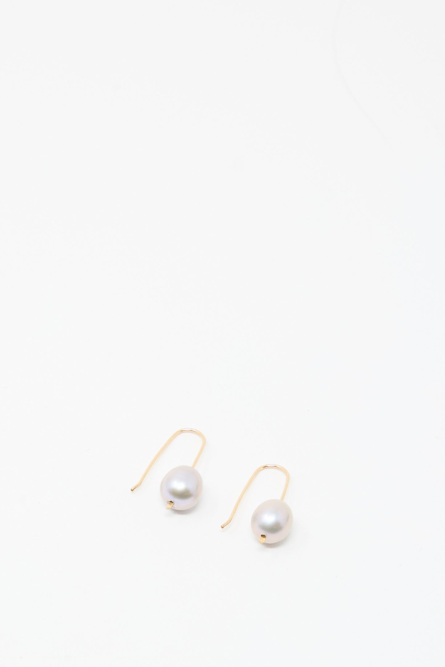 Mary MacGill Petite Baroque Pearl Drop Earrings in Silver, featuring a single round baroque pearl on silver-filled hooks, handmade in the Hudson Valley and displayed against a plain white background.