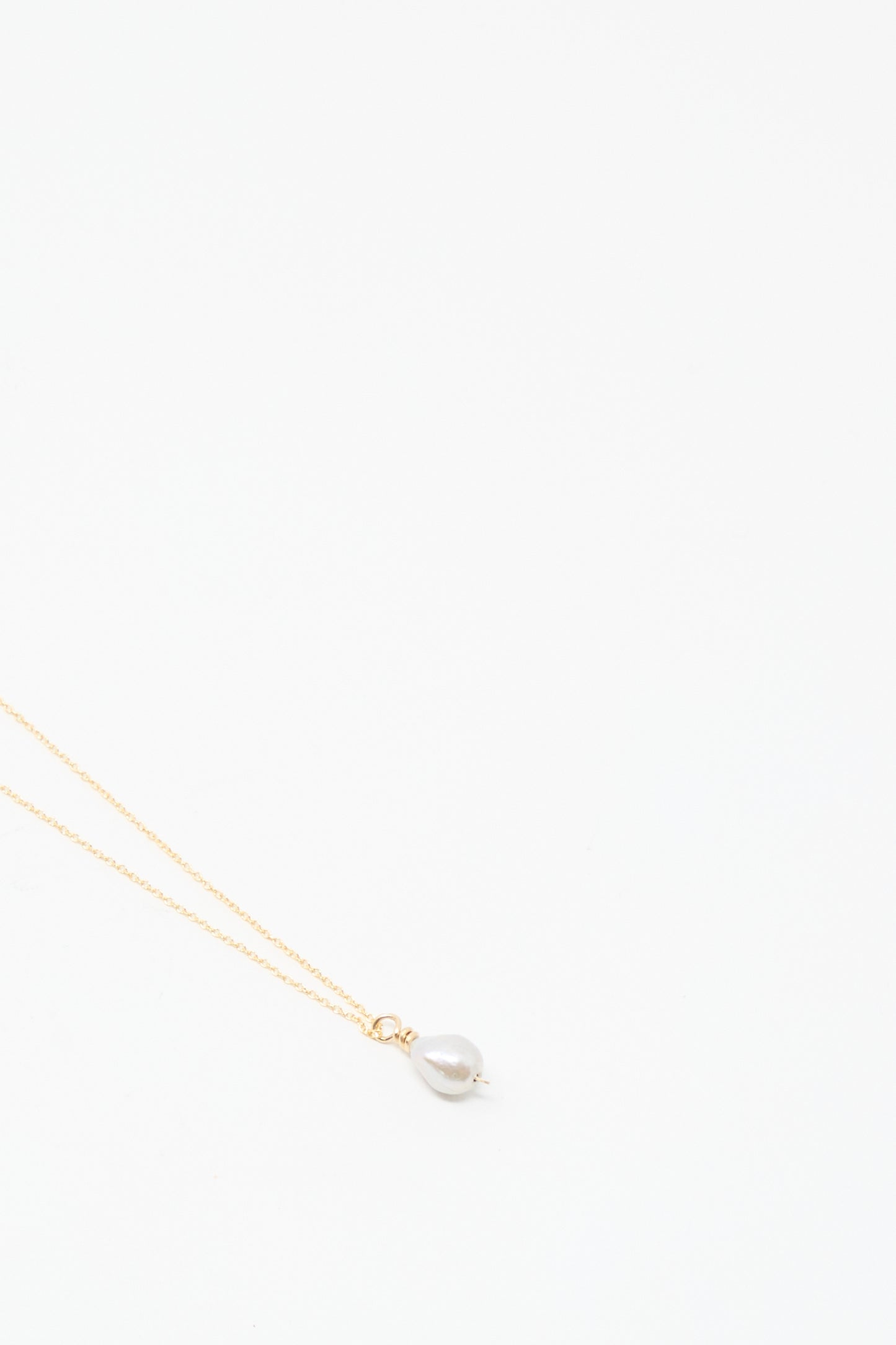 The Mary MacGill Petite Baroque Pearl Drop Necklace in Silver is handmade and features a single baroque pearl pendant, shown on a plain white background.